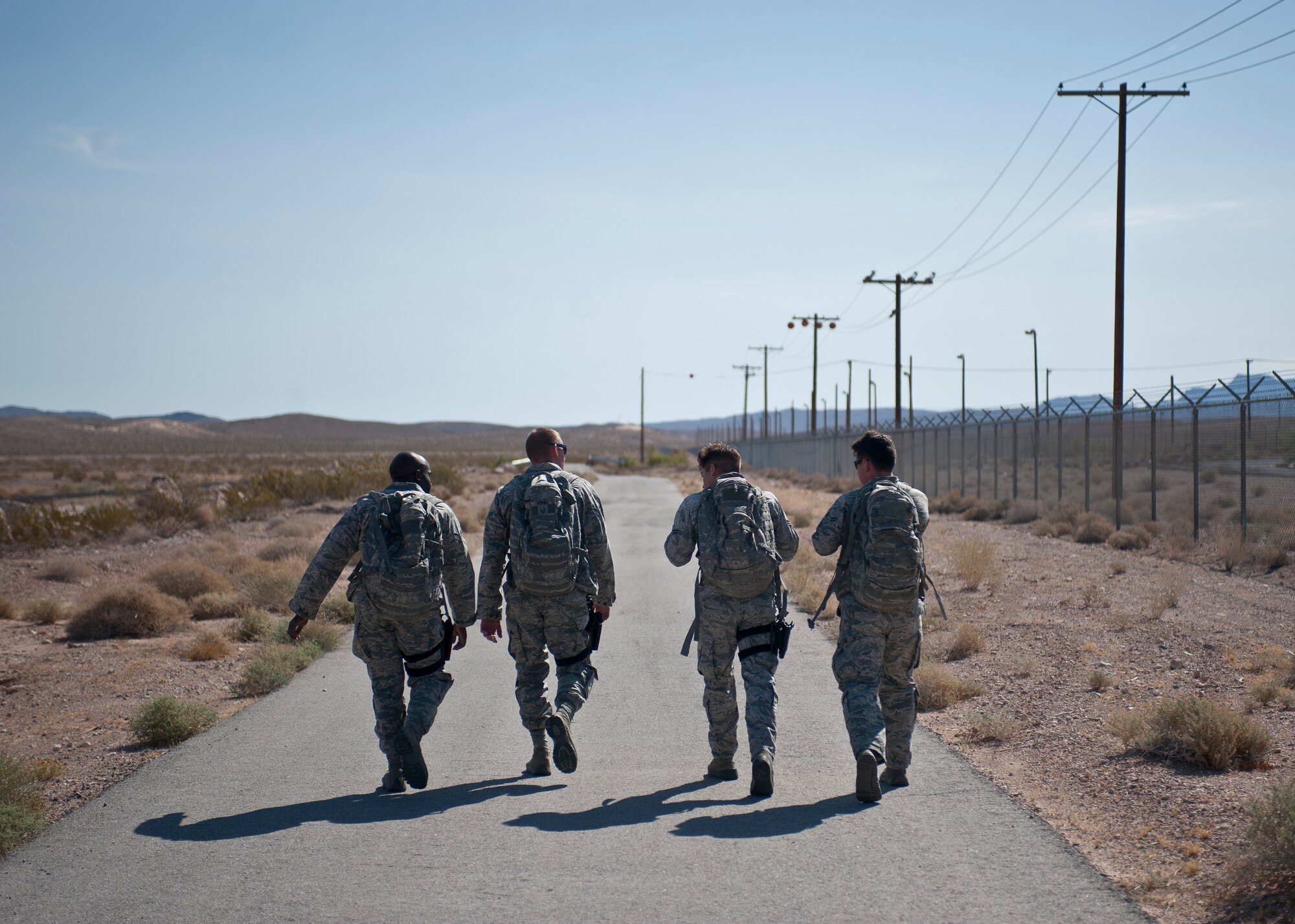 Participants in the Warrior Challenge walk during the one-mile ruck march portion of the competition at Nellis Air Force Base, Nev., May 29, 2015. The team that completed each of the obstacles/tasks -- weapons assembly, simunitions room clearing, self-aid buddy care carries, ruck march, 400 pushups and situps, and the shoot, move and communicate course – in the fastest overall time was declared the winner of the contest. (U.S. Air Force photo by Staff Sgt. Siuta B. Ika)