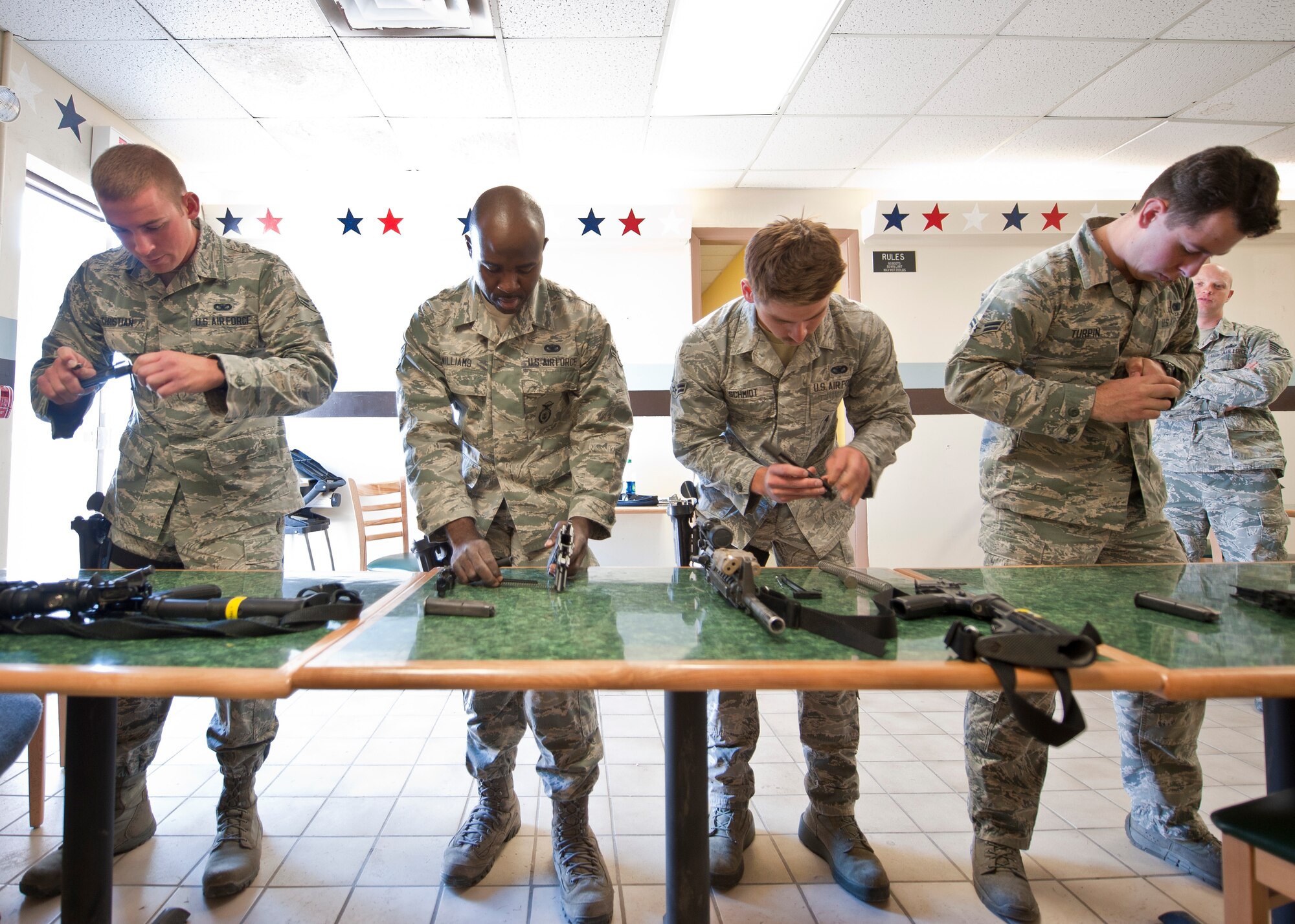 Participants in the Warrior Challenge assemble M-4 carbine rifles and M-9 pistols during the competition at Nellis Air Force Base, Nev., May 29, 2015. During the weapons assembly portion of the contest, each team of four had five minutes to completely assemble four different weapons. (U.S. Air Force photo by Staff Sgt. Siuta B. Ika)