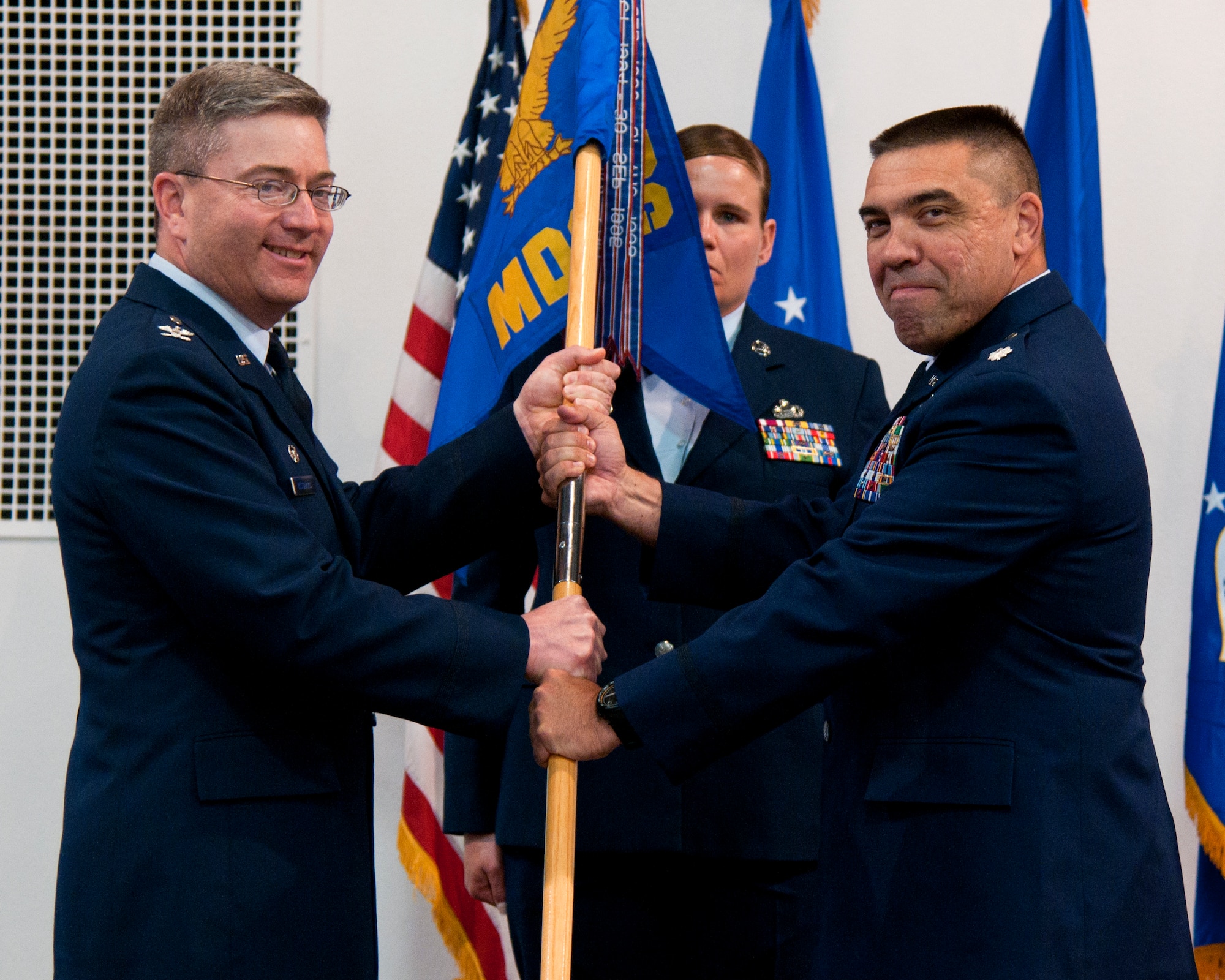 Col. Hans Ritschard, 90th Medical Group commander, passes the guidon to Lt. Col. Timothy Christison, 90th Medical Support Squadron commander, during the 90th MDSS change of command ceremony June 5, 2015, at F.E. Warren Air Force Base, Wyo. The ceremony signified the transition of command from Lt. Col. David Brown to Christison. (U.S. Air Force photo by Airman 1st Class Malcolm Mayfield)