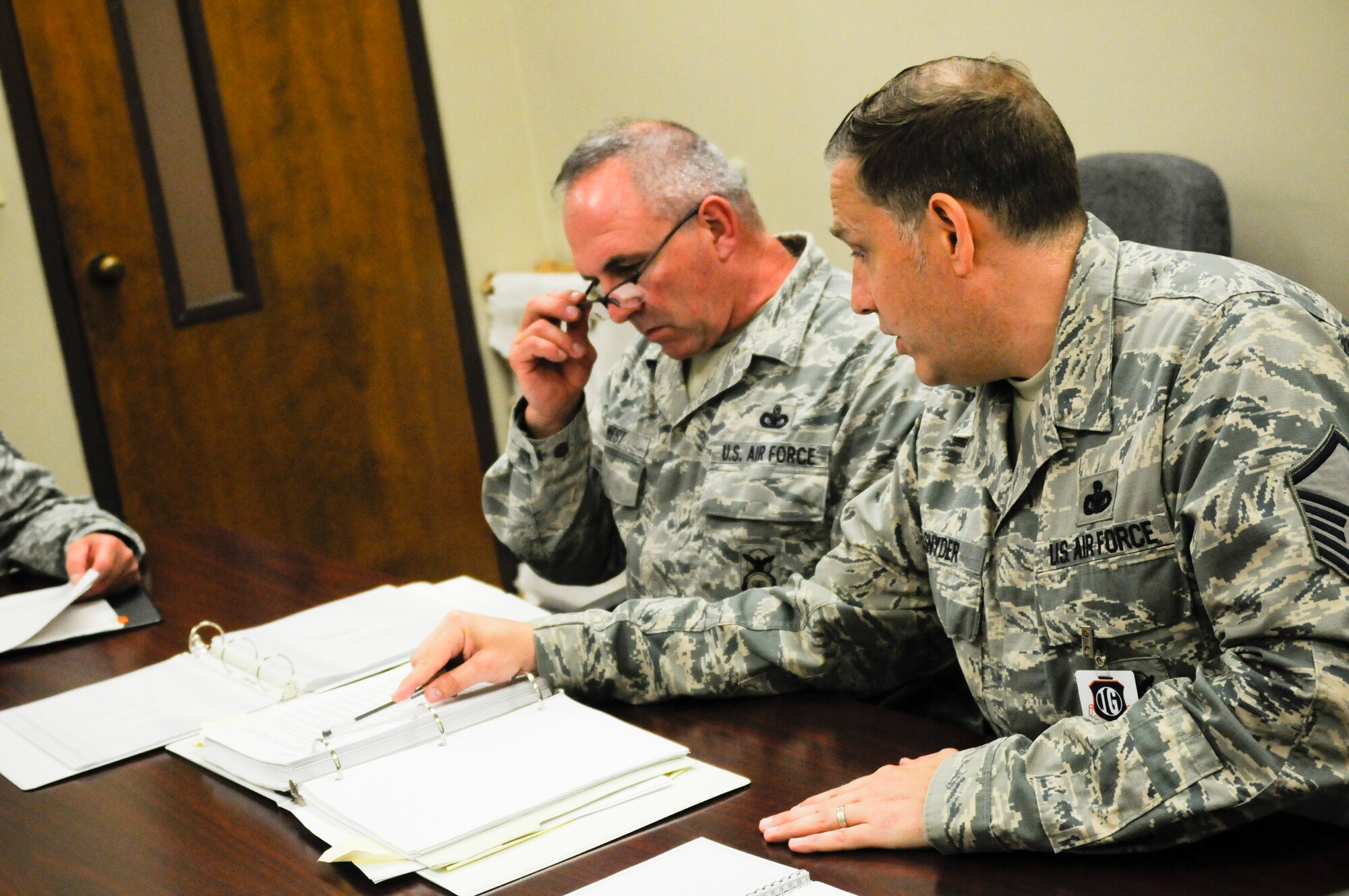 Master Sgt. Micah Snyder, command security forces inspector stationed at Joint Base Langley-Eustis, Va., talks with Senior Master Sgt. Larry Laney, 188th Security Forces Squadron Wing Inspection Team member, and Master Sgt. Chad West, 188th Security Forces Squadron non-commissioned officer in charge of training, about the current status of the training program in the 188th SFS. Snyder offered advice and techniques for enhancing the WIT member’s inspection and also how program managers can better prepare themselves for future inspections. (U.S. Air Force photo by Capt. Holli Nelson) 