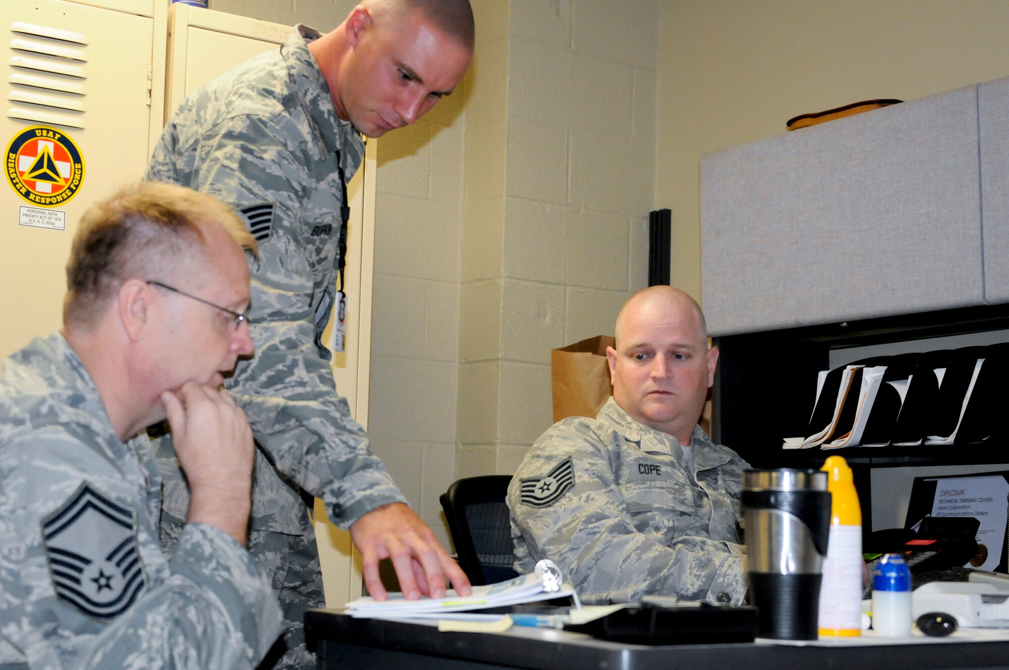 Tech. Sgt. Terry Bufkin (center), command security forces inspector stationed at Joint Base Langley-Eustis, Va., goes over self-inspection checklist items with Senior Master Sgt. Edgar Mahan and Tech Sgt. Joseph Cole, both assigned to the 188th Security Forces Squadron. The ACC IG inspectors spent two days visiting Security Forces and Civil Engineer Squadrons and working with Wing Inspection Team members on the proper techniques and procedures for conducting program inspections. (U.S. Air Force photo by Capt. Holli Nelson)