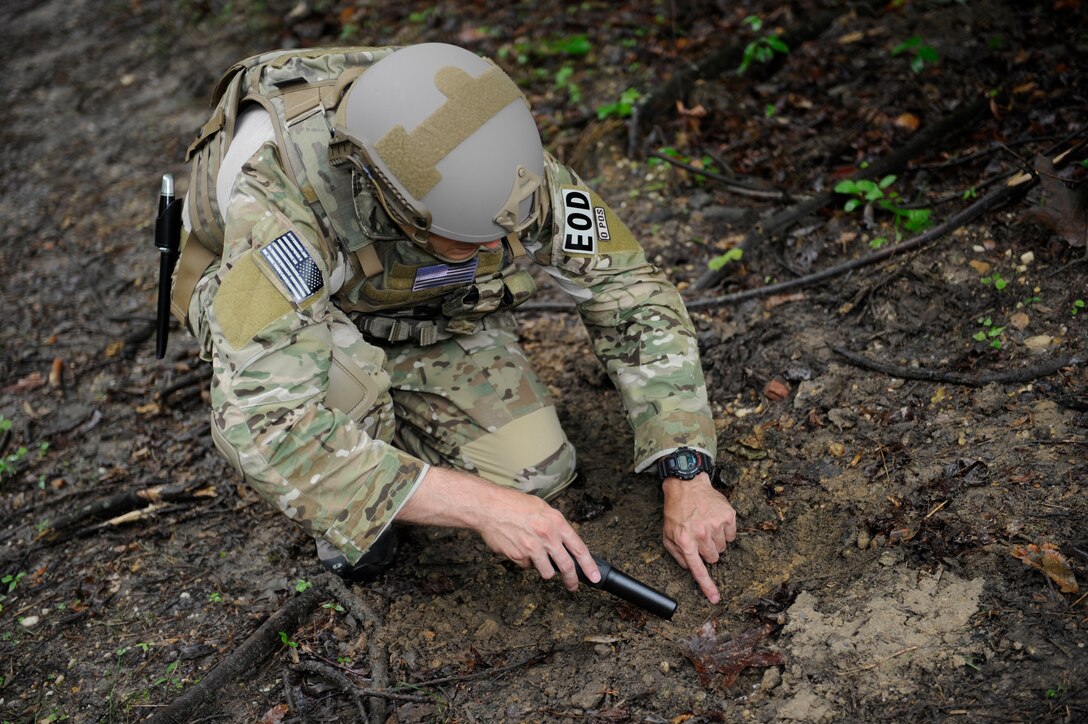 Staff Sgt. Luke Mefford, 11th Civil Engineer Squadron Explosive Ordnance Disposal training and quality control technician, inspects a patch of discolored dirt with a metal detector June 4, 2015, on Joint Base Andrews, Md. Disturbed or discolored dirt can be a sign of a buried Improvised Explosive Device. (U.S. Air Force photo by Senior Airman Preston Webb/Released)