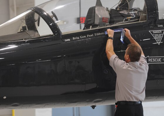Bob Wood, 394th Combat Training Squadron T-38 Talon Crew Chief, unveils the name of the 509th Bomb Wing commander, Air Force Brig. Gen. Paul W. Tibbets IV, on a T-38 aircraft during the change of command ceremony at Whiteman Air Force Base, Mo., June 5, 2015. As part of an Air Force tradition, one aircraft is painted with the new commander’s name. (U.S. Air Force photo by Staff Sgt. Alexandra M. Longfellow/Released)