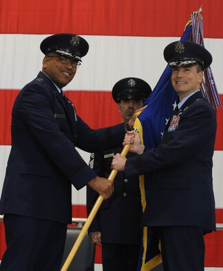 Air Force Maj. Gen. Richard Clark, Eighth Air Force commander, hands over the wing guidon to Brig. Gen. Paul W. Tibbets IV, 509th Bomb Wing commander, during the change of command at Whiteman Air Force Base, Mo., June 5, 2015. Presentation of the guidon to Tibbets symbolizes the official change of command from the old commander to the new commander. (U.S. Air Force photo by Staff Sgt. Alexandra M. Longfellow/Released)