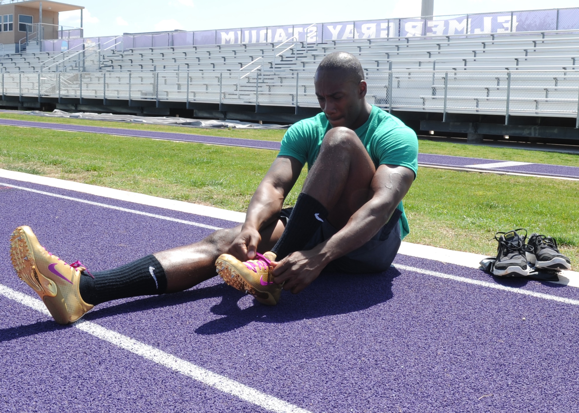 U.S. Air Force Senior Airman Kwesi Toney, 7th Logistics Readiness Squadron equipment accountability clerk, puts on his track spikes at Abilene Christian University May 18, 2015, in Abilene, Texas. Toney competed in long jump, javelin and the 4x100 meter relay at the 2015 Headquarter Air Command Track and Field Championship. Toney came in 6th place in long jump, 8th in javelin and 2nd in the relay.(U.S. Air Force photo by Senior Airman Shannon Hall/Released)