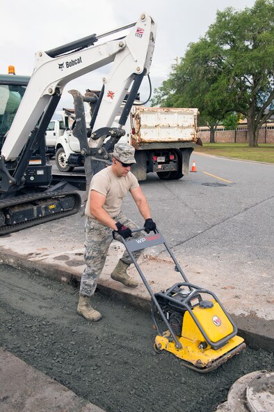 U.S. Air Force Senior Airman Brandon Devine, 23d Civil Engineer Squadron heavy equipment operator, uses a plate compactor during a road repair June 1, 2015, at Moody Air Force Base, Ga. Devine compacted the base course in preparation for rain to prevent saturation. (U.S. Air Force photo by Airman Greg Nash/Released) 
