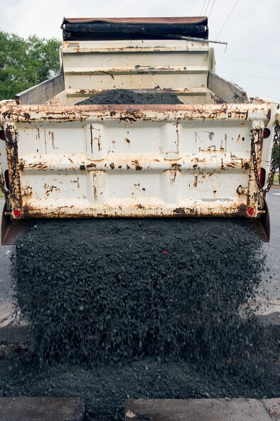 Base course is poured into a 10-inch deep hole during a road repair June 1, 2015, at Moody Air Force Base, Ga. Members of the 23d Civil Engineer Squadron used base course as a foundation to ensure that the new concrete will settle correctly when laying the pavement. (U.S. Air Force photo by Airman Greg Nash/Released)