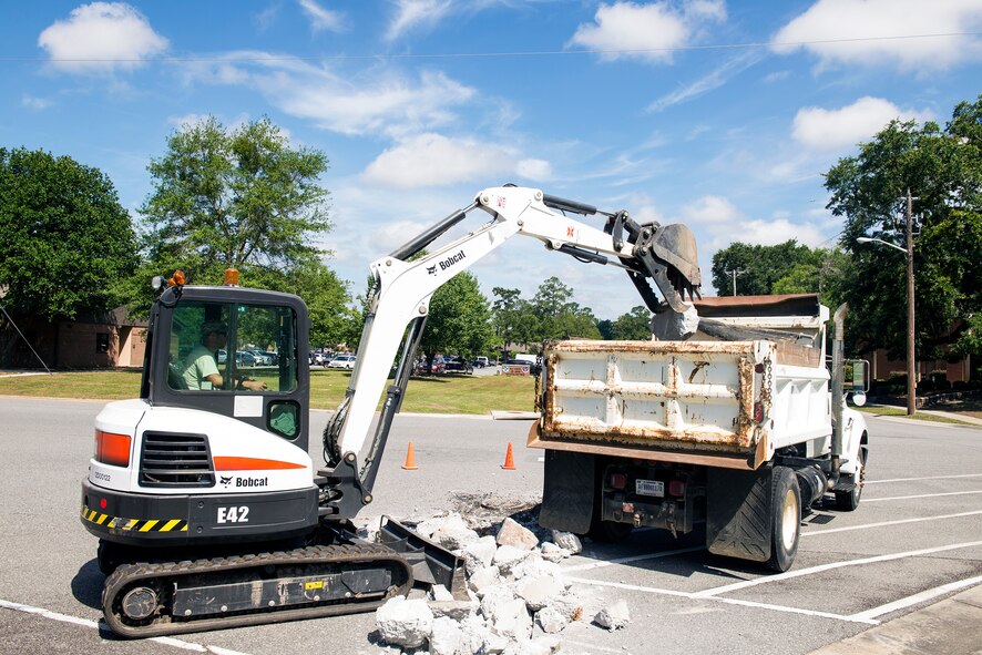 U.S. Air Force Senior Airman David Wakeman, 23d Civil Engineer Squadron heavy equipment operator, maneuvers a mini excavator to drop off dismantled concrete June 1, 2015, at Moody Air Force Base, Ga. Wakeman’s responsibilities consist of constructing, maintaining, and inspecting concrete and asphalt structures. (U.S. Air Force photo by Airman Greg Nash/Released) 