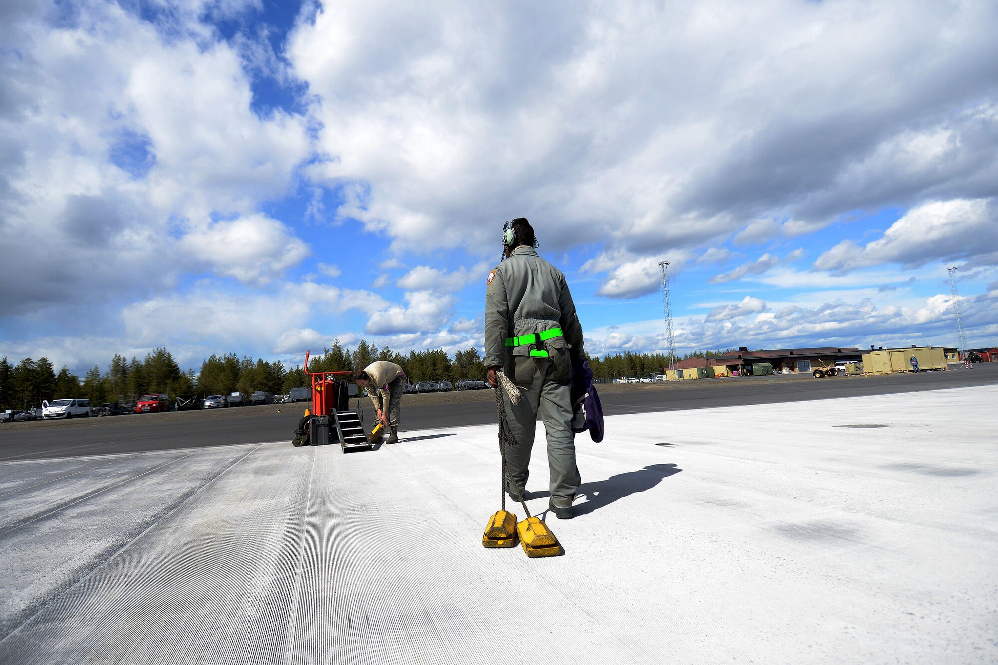 U.S. Air Force Airman 1st Class Keitha Whitaker Jr., 31st Aircraft Maintenance Squadron crew chief, removes chalks from an apron at Kallax Air Base, Sweden, June 2, 2015 during Arctic Challenge Exercise 2015. Nine nations participated in the exercise to help ensure interoperability and strengthen relationships with NATO allies and Partners for Peace.  (U.S. Air Force photo by Staff Sgt. Evelyn Chavez/Released)