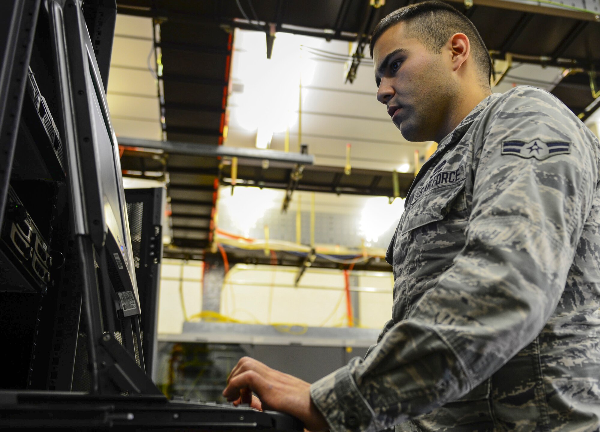 Airman 1st Class Ruben Gracia-Garcia, 48th Communications Squadron cyber systems operator, works on base servers using a Keyboard Video Mouse at Royal Air Force Lakenheath, England, June 3, 2015. The CS rebuilt the Interactive Electronic Technical Manual servers for the 48th Component Maintenance Squadron, shortening the log on time from an average of 30 minutes to 26 seconds. (U.S. Air Force photo by Airman 1st Class Dawn M. Weber/Released)