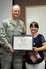 Col. Michael A. Vogel, 66th Air Base Group commander, presents Sibylle Stroup a certificate of appreciation for her work with the base Key Spouse Program during a Key Spouse Appreciation Event June 3. Stroup, as well as Staci Claffey and Brenda Anthony were recognized at the event. (U.S. Air Force photo by Linda LaBonte Britt)