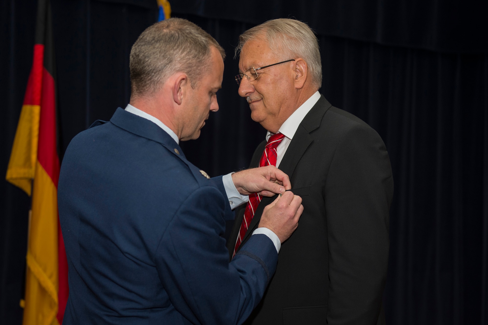 U.S. Air Force Lt. Col. Christopher Meeker, 52nd Civil Engineer Squadron commander, pins the Exemplary Civilian Service medal on Peter Kranz, 52nd CES financial manager and retiree, during a retirement ceremony at Spangdahlem Air Base, May 29, 2015. Kranz initially worked at Bitburg Air Base, Germany, until he transferred to Spangdahlem where he has spent the last 19 years. Kranz retired after a total of 46 years. (U.S. Air Force photo by Airman 1st Class Luke Kitterman/Released)