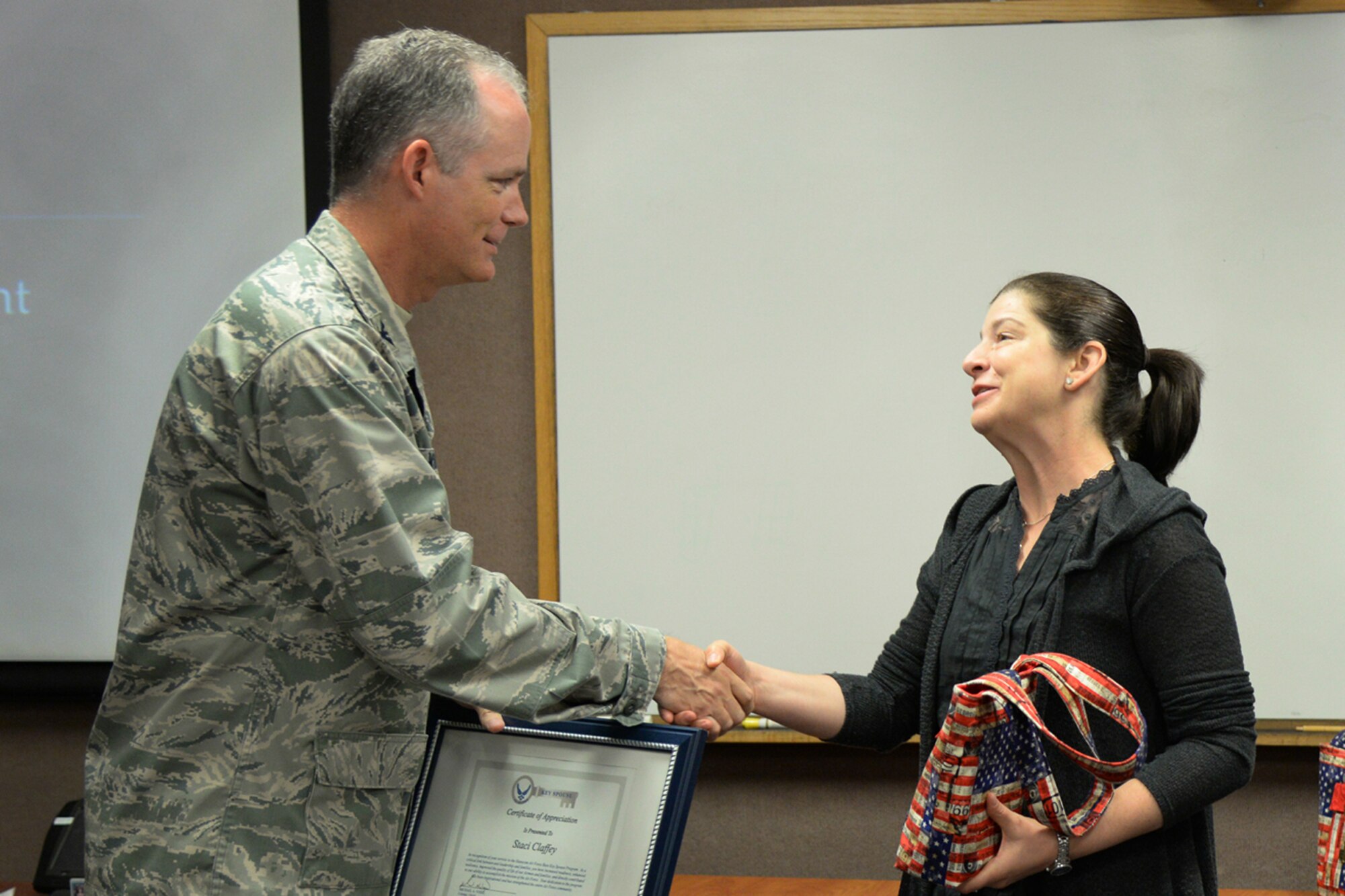 Col. Michael A. Vogel, 66th Air Base Group commander, presents Staci Claffey a certificate of appreciation for her work with the base Key Spouse Program during a Key Spouse Appreciation Event June 3. Claffey, as well as Sibylle Stroup and Brenda Anthony were recognized at the event. (U.S. Air Force photo by Linda LaBonte Britt)