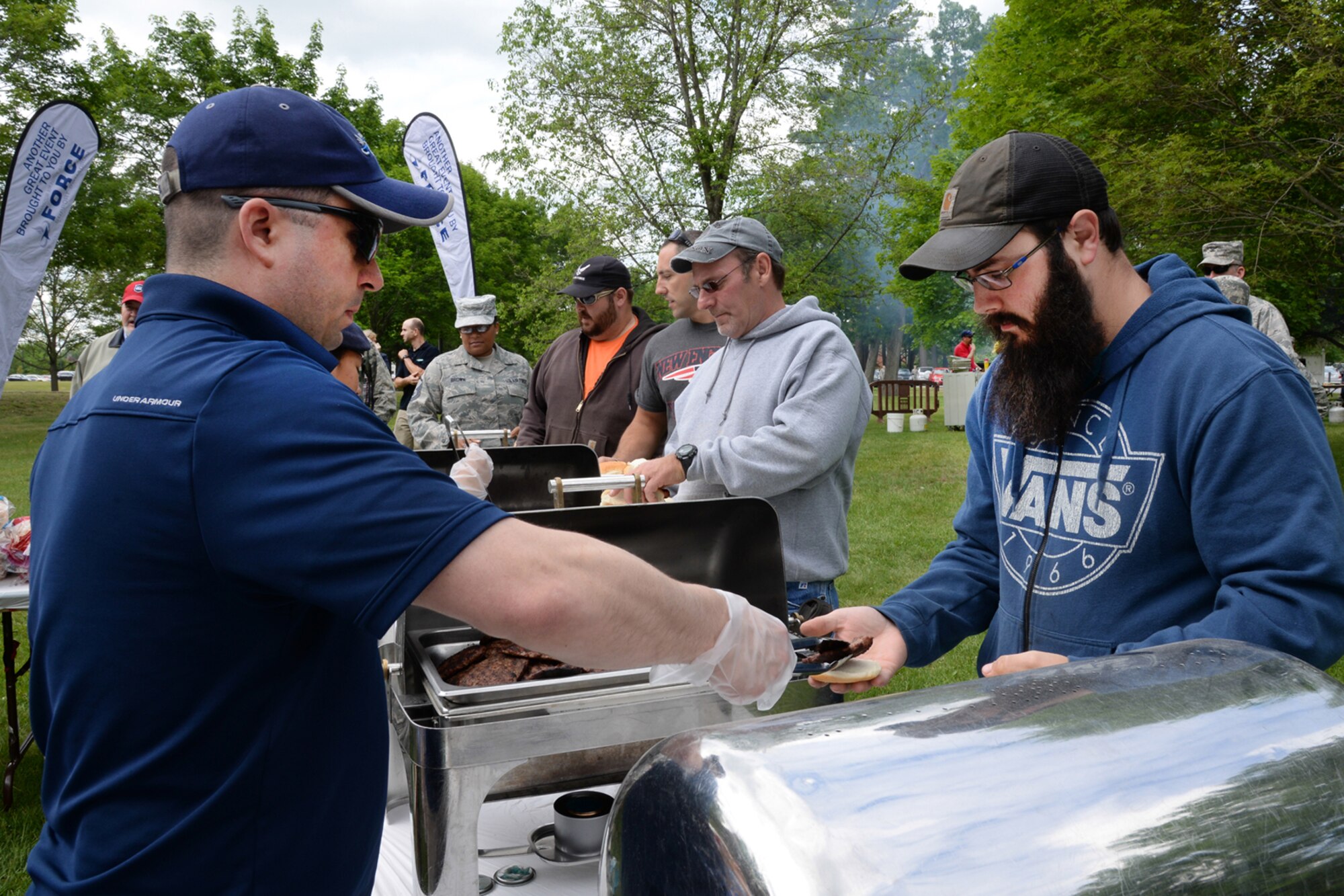 Maj. Sidney Squires, 66th Force Support Squadron deputy director, serves lunch to Ryan Pickering, 66th Civil Engineering Division grounds maintenance, during a base wide picnic June 4 at the base chapel to celebrate recent inspection results. The 66th Air Base Group had a Unit Effectiveness Inspection, while the Battle Management and Command, Control, Communications, Intelligence and Networks Directorates underwent Unit Compliance Observations. All major organizations at Hanscom scored an "effective" or better in their perspective Major Graded Areas. (U.S. Air Force photo by Linda LaBonte Britt)