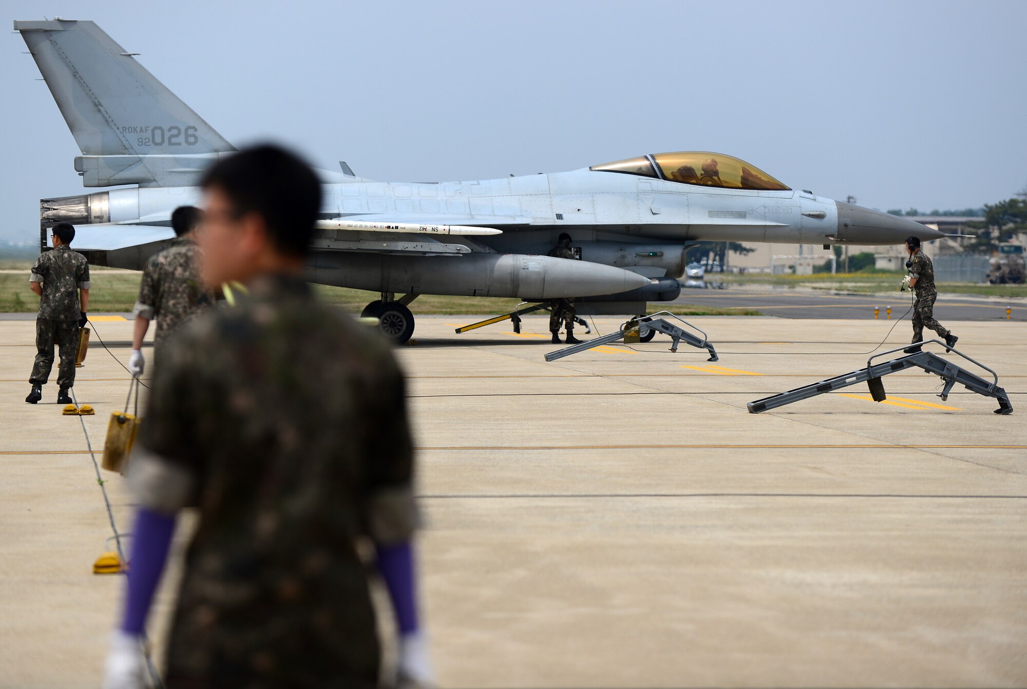 Republic of Korea Air Force KF-16 Fighting Falcon crew chiefs wait as a KF16 from the 123rd Tactical Fighter Squadron, 20th Fighter Wing, Seosan Air Base, arrives at Kunsan Air Base, ROK, for Exercise Buddy Wing 15-4, June 1, 2015. ROKAF pilots routinely train with U.S. Air Force pilots to enhance interoperability and sharpen their combined airpower skills during Buddy Wing exercises multiple times throughout the year. (U.S. Air Force photo by Staff Sgt. Nick Wilson/Released)