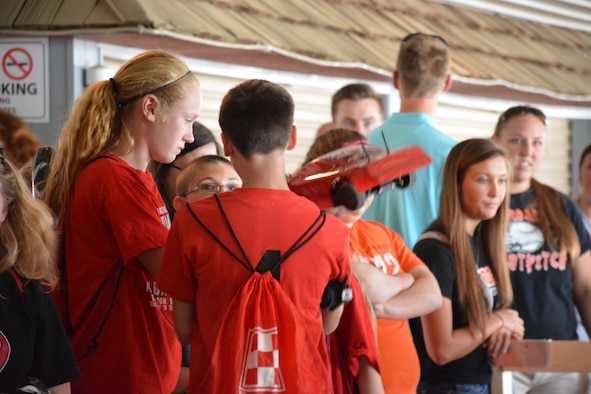 Aubrey Stupp, a 7th grade student at Tri-County North, shows her race car to 8th grade team mates Brandon Smeltzer and Hunter Heck (at Eldora Speedway on May 6, 2015.  The course race is part of the 3rd Annual Full Throttle STEM event sponsored by the 711 Human Performance Wing. (U.S. Air Force photo by Gary Rankin / Released)