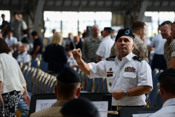 A Soldier conducts the Joint Service band at the United States Forces, Japan, and 5th Air Force change of command ceremony at Yokota Air Base, Japan, June 5, 2015. The Pacific Air Forces commander, Gen. Lori Robinson, presided over the ceremony, passing the USFJ/5AF command from Lt. Gen. Salvatore Angelella to Lt. Gen. John Dolan. (U.S. Air Force photo by Staff Sgt. Cody H. Ramirez/Released)

