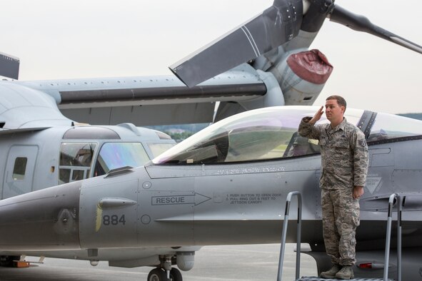 Staff Sgt. Justin Wilson, 35th Aircraft Maintenance Squadron crew chief, salutes the new United States Forces Japan and 5th Air Force commander, Lt. Gen. John Dolan, after revealing the incoming commander's name on the flagship F-16 Fighting Falcon during the USFJ and 5th AF change of command ceremony at Yokota Air Base, Japan, June 5, 2015. (U.S. Air Force photo by Osakabe Yasuo/Released)