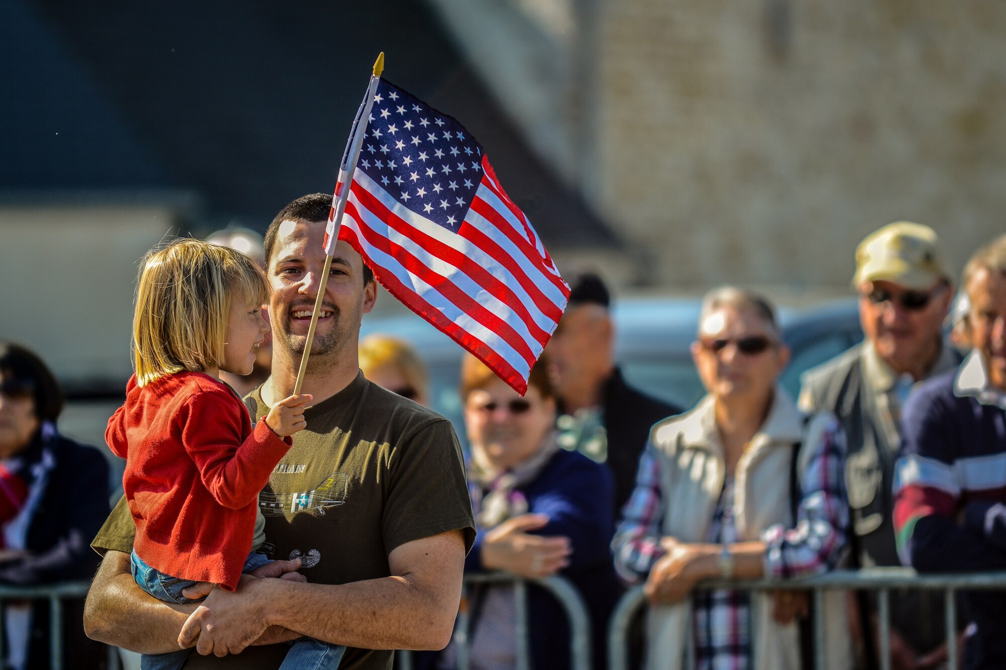 A father holds his daughter during a memorial ceremony at the Picauville 9th Air Force monument June 4, 2015, in Normandy, France. More than 380 service members from Europe and affiliated D-Day historical units are participating in the 71st Anniversary as part of Joint Task Force D-Day 71. The task force, based in Saint Mere Eglise, France, is supporting local events across Normandy, June 2-8, 2015, to commemorate the selfless actions by all the Allies on D-Day that continue to resonate 71 years later. (U.S. Air Force photo/Senior Airman Nicole Sikorski)