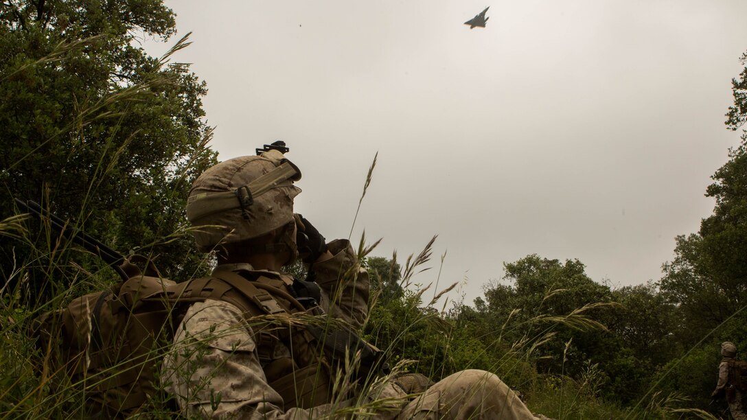 U.S. Marine Corps Lance Cpl. Daniel Ficci, a field radio operator with Special-Purpose Marine Air-Ground Task Force Crisis Response-Africa, observes a French aircraft displaying a ‘show of force’ in support of a bilateral training exercise on Quartier Colonel de Chabrieres, France, May 29, 2015. Marines stationed at Moròn Air Base, Spain, conducted a seize and capture training exercise with service members from the French Foreign Legion’s 6th Light Armored Brigade to further improve interoperability between the two NATO forces as they concurrently deploy their service members to Africa. 
