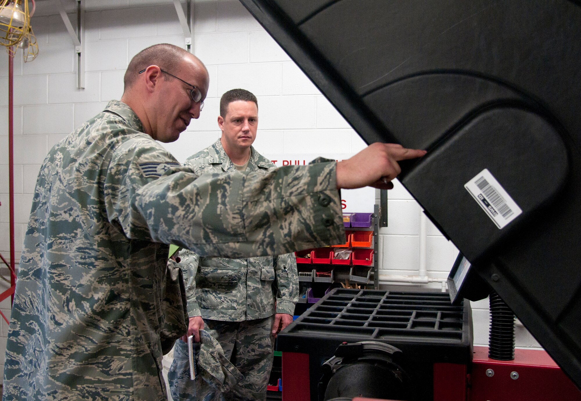 Staff Sgt. Philip Bolduc, 90th Logistics Readiness Squadron vehicle maintenance customer service NCOIC and safety representative, explains the 90th LRS tire balancer to Master Sgt. Michael Moriarty, 90th Missile Wing Safety Office ground safety superintendent, June 4, 2014, during the annual safety inspection of the 90th Logistics Readiness Squadron in the vehicle maintenance building. The focus of the inspection is to ensure the Airmen are safe in their working environment. (U.S. Air Force photo by Airman 1st Class Malcolm Mayfield)