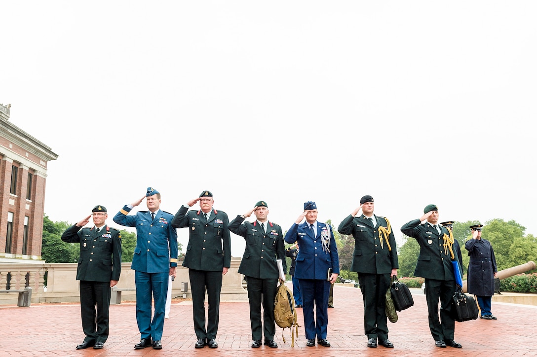 Canadian and U.S. service members salute during the playing of each country's national anthem, prior to the start of the U.S.-Canada Defense Chiefs Strategy Dialogue at the National Defense University in Washington, D.C., June 4, 2015. 