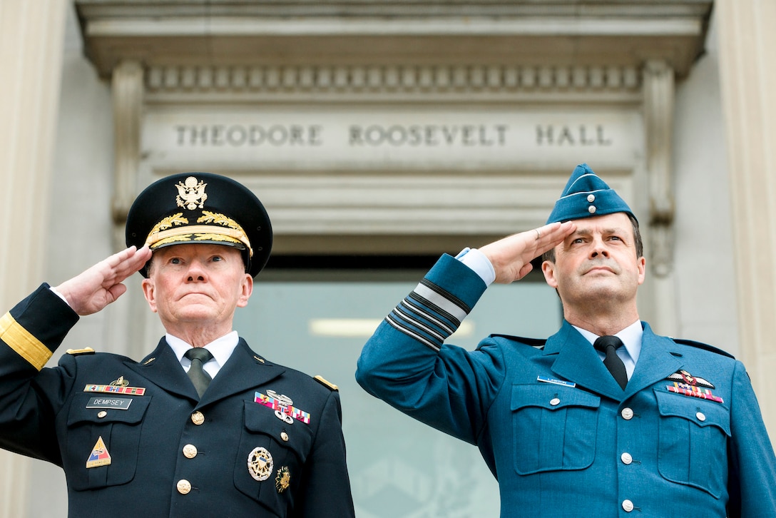 U.S. Army Gen. Martin E. Dempsey, right, chairman of the Joint Chiefs of Staff, and Canadian Air Force Gen. Thomas J. Lawson, chief of the defense staff of Canada's armed forces, salute during the playing of each country's national anthem, prior to the start of the U.S.-Canada Defense Chiefs Strategy Dialogue at the National Defense University in Washington, D.C., June 4, 2015. 