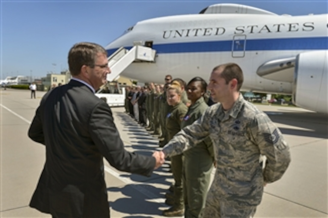 U.S. Defense Secretary Ash Carter offers a coin and a handshake to aircrew personnel as he prepares to board an E4-B aircraft in Stuttgart, Germany, June 5, 2015, ending a 10-day trip. Carter also traveled to Hawaii, Singapore, Vietnam and India to meet with leaders and troops.