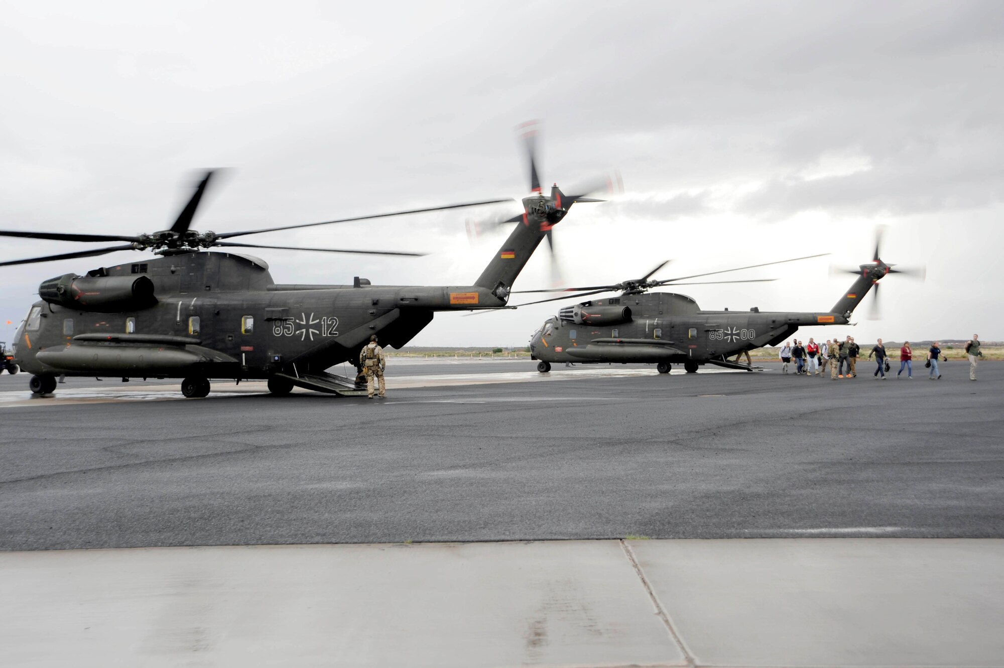 Simulated flood victims are escorted from a German Air Force CH-53GS by a German Air Force pararescueman during an Angel Thunder 2015 mass casualty exercise at Winslow-Lindbergh Regional Airport, Ariz., June 5, 2015. U.S. military forces and partner nations worked together during the exercise to transport simulated patients from Camp Navajo Training Site to the casualty collection point located at the Winslow???Lindbergh Regional Airport. (U.S. Air Force photo/Tech. Sgt. Courtney Richardson/Released)