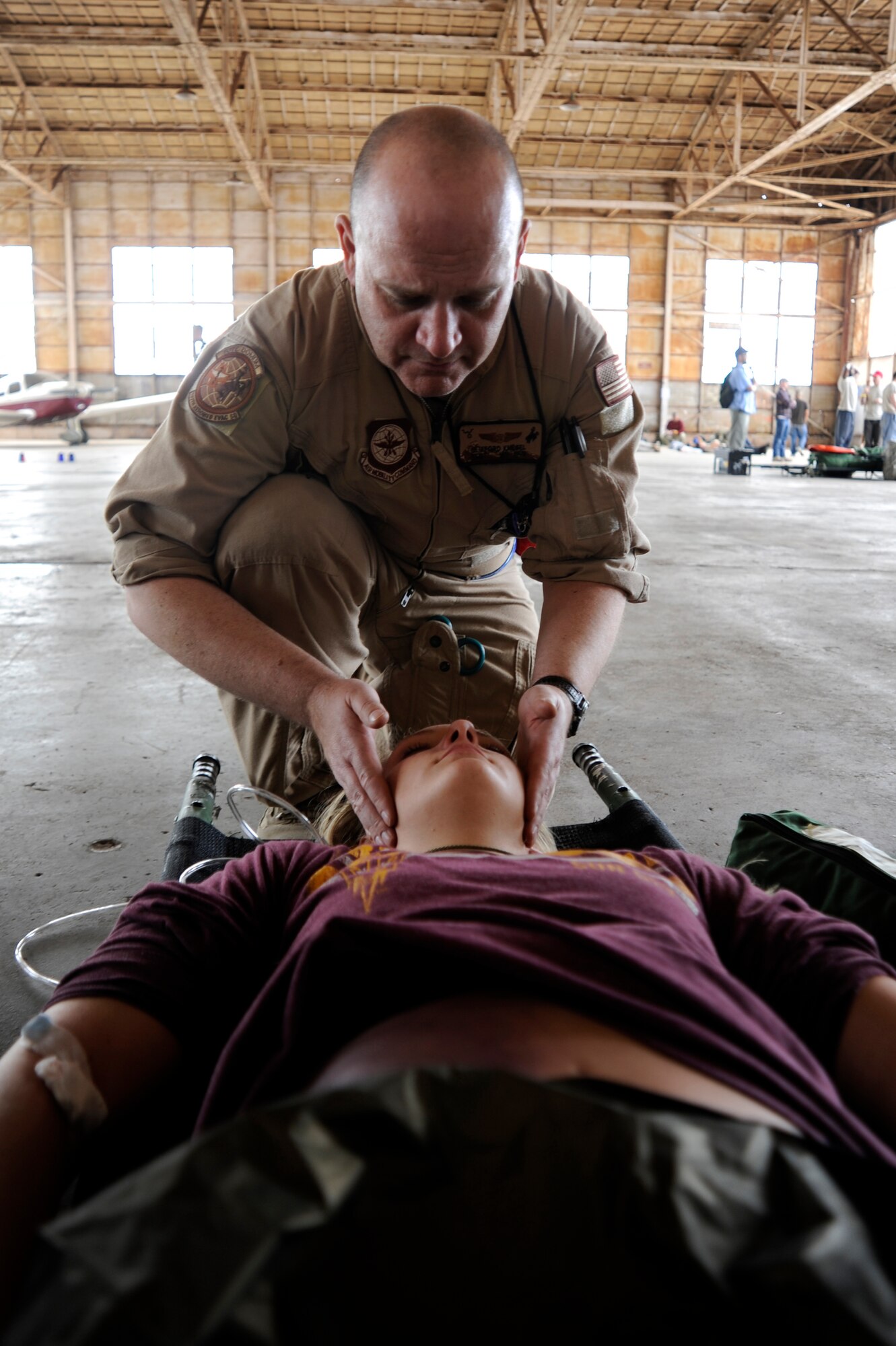 U.S. Air Force Tech. Sgt. Clifford Knesel, 187th Aeromedical Evacuation Squadron medical technician, stabilizes the head of a simulated flood victim with internal bleeding during an Angel Thunder 2015 mass casualty exercise at Winslow-Lindbergh Regional Airport, Ariz., June 5, 2015. U.S. military forces and partner- nations worked together during the exercise to transport patients from Camp Navajo Training Site to the casualty collection point located at the Winslow-Lindbergh Regional Airport. Knesel is a member of the Wyoming Air National Guard. (U.S. Air Force photo/Tech. Sgt. Courtney Richardson/Released)