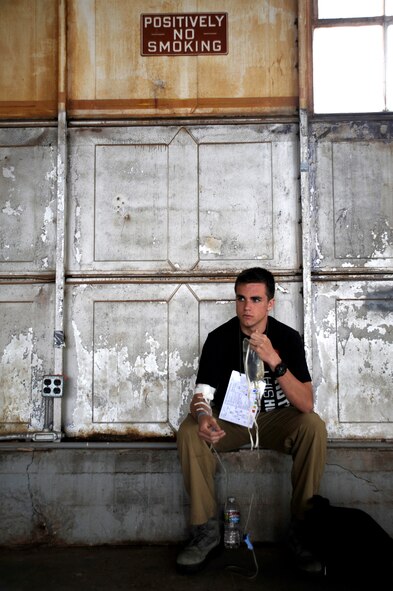 U.S. Air Force Staff Sgt. Joseph Kaupas, 355th Aircraft Maintenance Squadron weapons load team chief and simulated patient, holds an IV after receiving medical care during an Angel Thunder 2015 mass casualty exercise at Winslow-Lindbergh Regional Airport, Ariz., June 5, 2015. Service members, University of Arizona and Northern Arizona University students acted as simulated patients to create a realistic experience during the exercise. (U.S. Air Force photo/Tech. Sgt. Courtney Richardson/Released)  