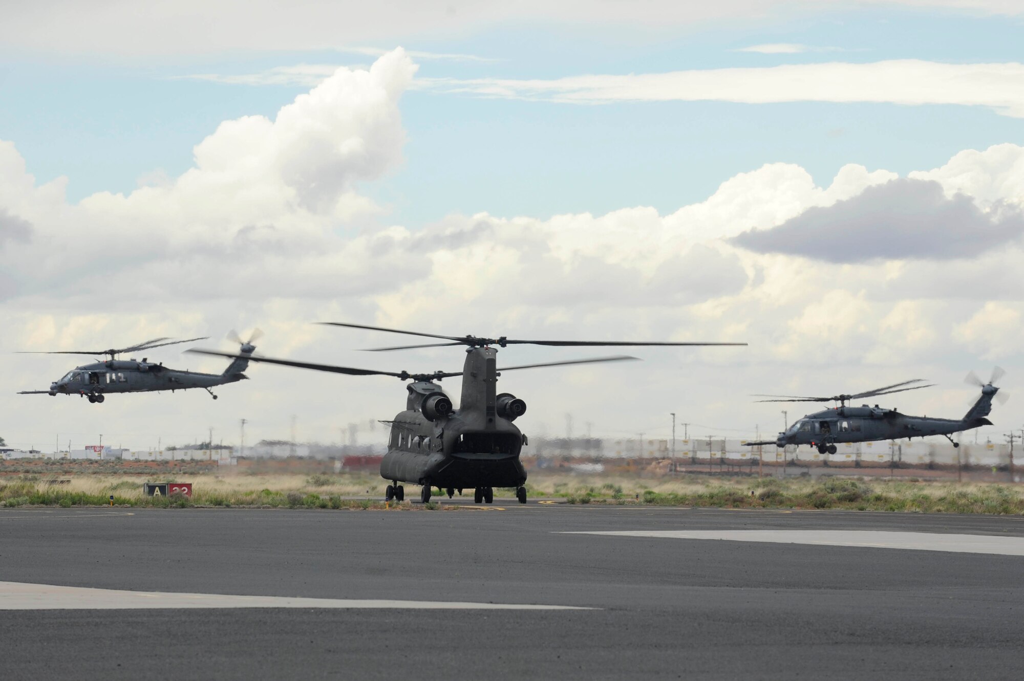 Two U.S. Air Force HH-60G Pave Hawks take off as a U.S. Army CH-47D taxis during an Angel Thunder 2015 mass casualty exercise at Winslow-Lindbergh Regional Airport, Ariz., June 5, 2015. U.S. military forces and partner nations worked together during the exercise to transport simulated patients from Camp Navajo Training Site to the casualty collection point located at the Winslow-Lindbergh Regional Airport. (U.S. Air Force photo/Tech. Sgt. Courtney Richardson/Released)
 
