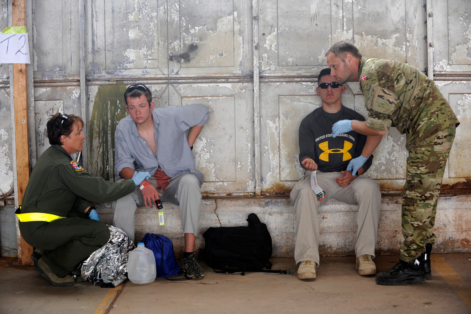 A U.S. Air Force Airman and a Royal Danish Air Force rescue member triage two simulated flood victims during an Angel Thunder 2015 mass casualty exercise at Winslow-Lindbergh Regional Airport, Ariz., June 5, 2015. U.S. military forces and partner- nations worked together during the exercise to transport simulated patients from Camp Navajo Training Site to the casualty collection point located at the Winslow-Lindbergh Regional Airport. (U.S. Air Force photo/Tech. Sgt. Courtney Richardson/Released)