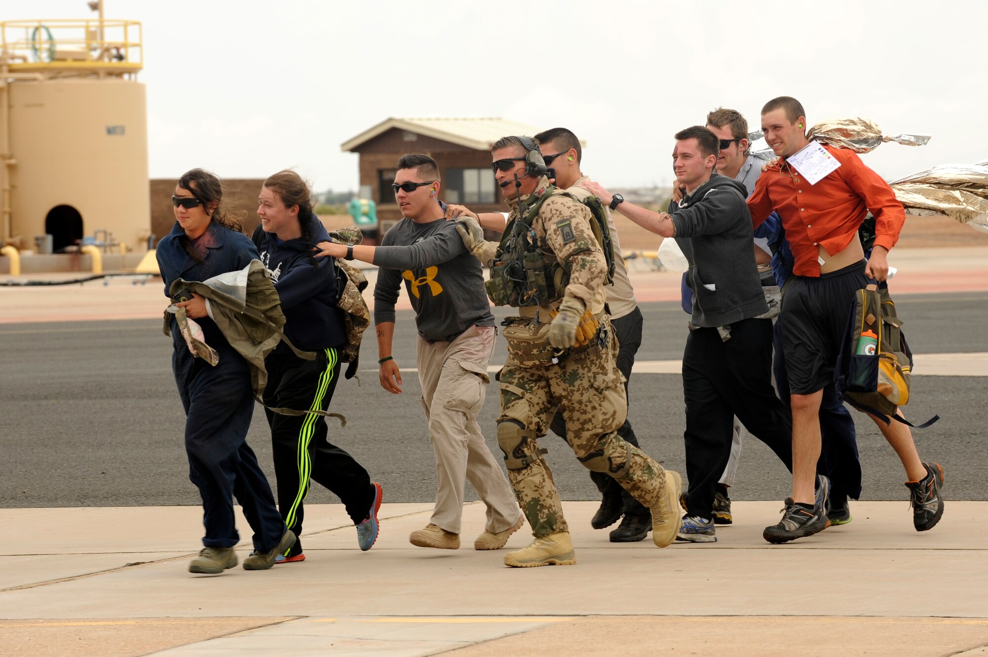 Simulated flood victims are escorted by a German Air Force pararescueman during an Angel Thunder 2015 mass casualty exercise at Winslow-Lindbergh Regional Airport, Ariz., June 5, 2015. U.S. military forces and partner- nations worked together during the exercise to transport simulated patients from Camp Navajo Training Site to the casualty collection point located at the Winslow-Lindbergh Regional Airport. (U.S. Air Force photo/Tech. Sgt. Courtney Richardson/Released)