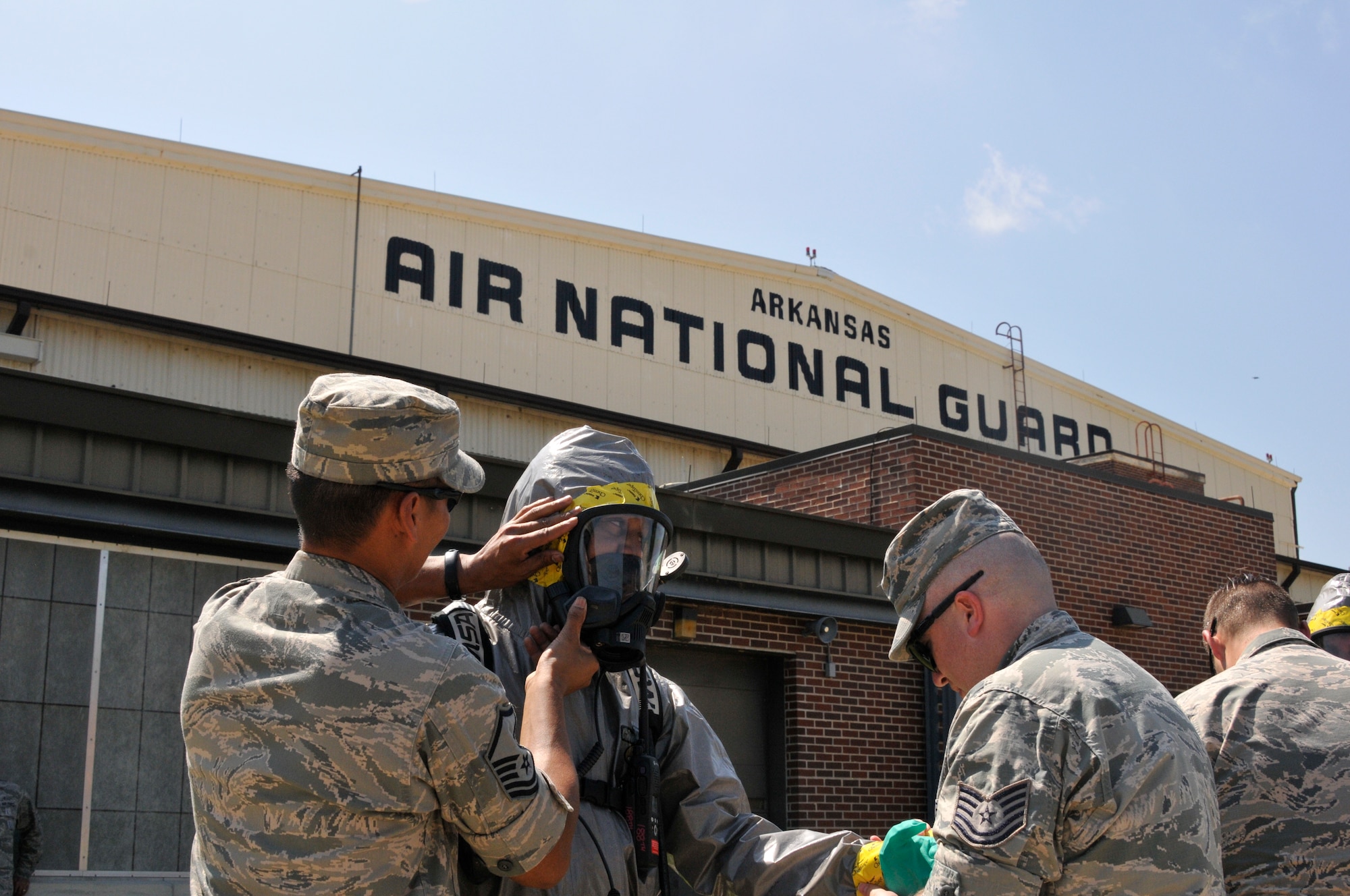 Senior Airman Kennan Wallace, 188th Emergency Management journeyman, receives help from his emergency management teammates in donning his hazardous materials level-A suit during June Unit Training Assembly on Ebbing Air National Guard Base, Fort Smith, Ark. Emergency managers can utilize hazardous materials level-A suits to respond to hazardous or toxic materials spills and go through rigorous training to become certified in their respective career fields. (U.S. Air National Guard photo by Staff Sgt. John Suleski/Released)