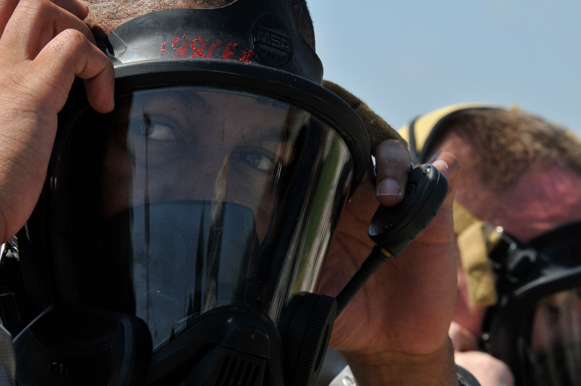 Senior Airman Keenan Wallace, 188th Emergency Management journeyman, dons a gas mask as part of his protective gear during June Unit Training Assembly on Ebbing Air National Guard Base, Fort Smith, Ark. Air Force emergency managers are trained in a wide array of specialties including hazardous materials operations, natural disaster response and nuclear, chemical and biological warfare training. (U.S. Air National Guard photo by Staff Sgt. John Suleski/Released)
