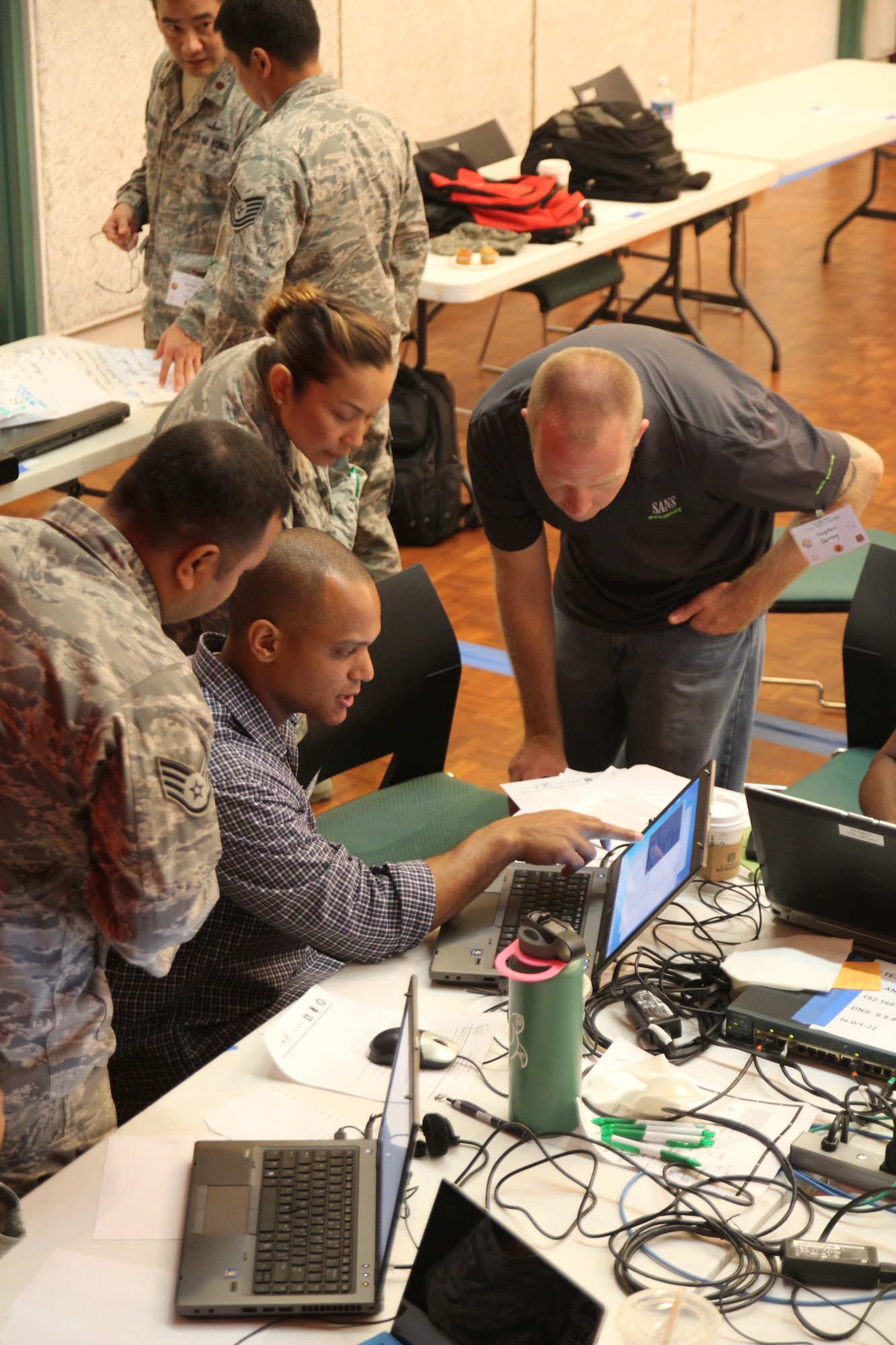 Hawaii Air National Guard airmen collaborate with civilians in the cyber security sector to defend against cyber attacks during the Po’oihe 2015 Cyber Security Exercise at the University of Hawaii Manoa Campus Center Ballroom on June 4, 2015. The exercise is a two-day event focused on the protection of commercial networks against cyber threats. It provides an opportunity for service members and industry professionals to discuss many of the challenges facing cyber security. (U.S. Air National Guard photo by Airman 1st Class Robert Cabuco)
