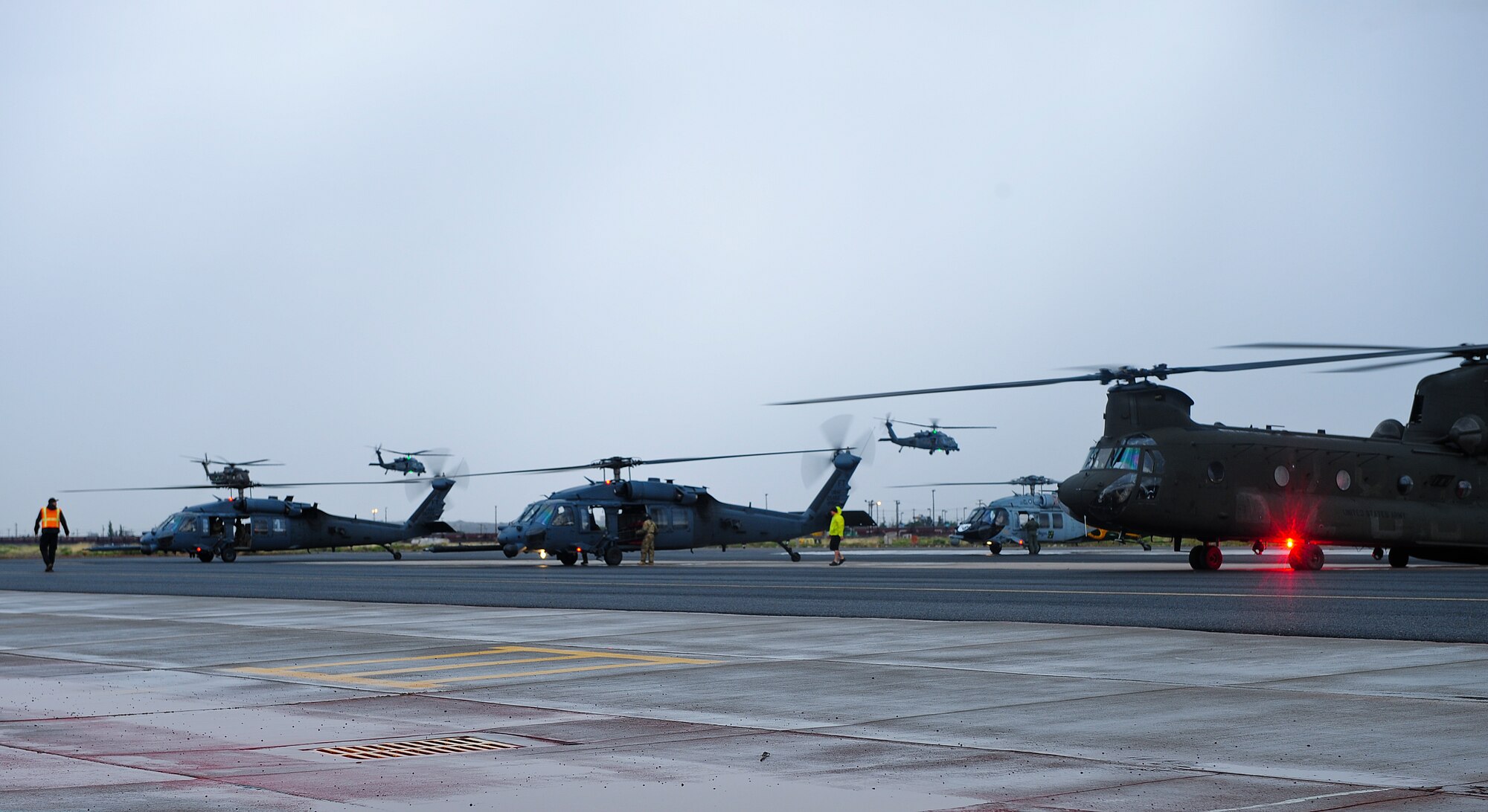 Two U.S. Air Force HH-60G Pave Hawks and a German CH-53GS helicopter take off while two U.S. Air Force HH-60G Pave Hawks, a U.S. Army CH-47D Chinook and a U.S Navy HH-60H Seahawk helicopter wait for clearance to take off after an Angel Thunder 2015 mass casualty exercise at Winslow-Lindbergh Regional Airport, Ariz., June 5, 2015. During the exercise, U.S. military forces and partner-nations worked together to transport simulated patients from Camp Navajo Training Site to the casualty collection point located at the Winslow-Lindbergh Airport. (U.S. Air Force photo by Airman 1st Class Chris Drzazgowski/Released)
