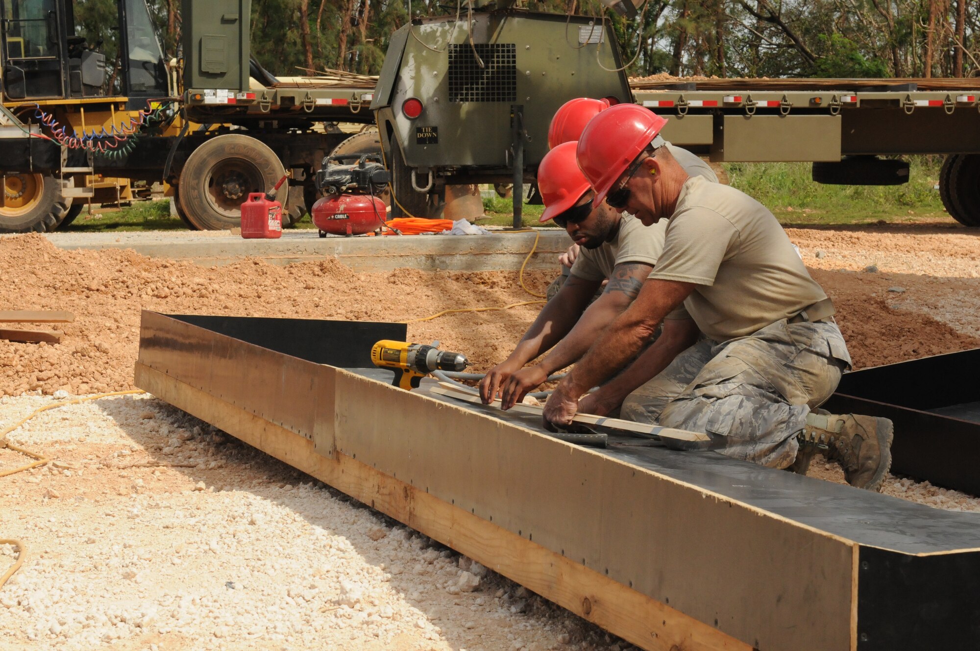 Airmen from the Virginia Air National Guard's Virginia Beach-based 203rd RED HORSE Squadron and the 202nd RHS from Camp Blanding, Florida improve and train upon essential skills June 2, 2015 during a joint-tasking training mission to erect a Facilities Systems Training facility at Anderson Air Force Base, Guam. The FST is a one-story, pre-cast concrete "Tilt-Up Construction" building using troop labor, under the Air National Guard Deployment for Training program. The facility is designed to withstand hurricane-force winds and earthquakes. (U.S. Air National Guard photo by Tech. Sgt. Meghan Skrepenski/Released)