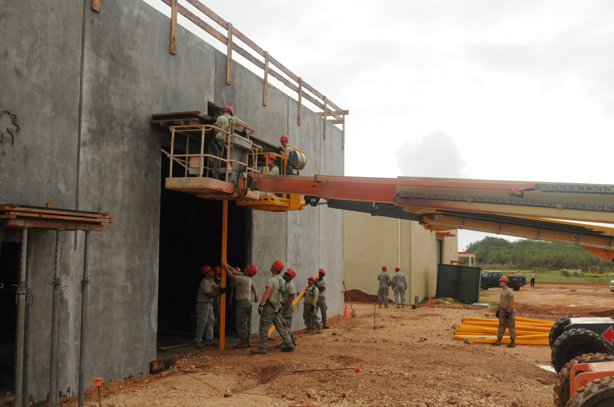 Airmen from the Virginia Air National Guard's Virginia Beach-based 203rd RED HORSE Squadron and the 202nd RHS from Camp Blanding, Florida improve and train upon essential skills June 2, 2015 during a joint-tasking training mission to erect a Facilities Systems Training facility at Anderson Air Force Base, Guam. The FST is a one-story, pre-cast concrete "Tilt-Up Construction" building using troop labor, under the Air National Guard Deployment for Training program. The facility is designed to withstand hurricane-force winds and earthquakes. (U.S. Air National Guard photo by Tech. Sgt. Meghan Skrepenski/Released)