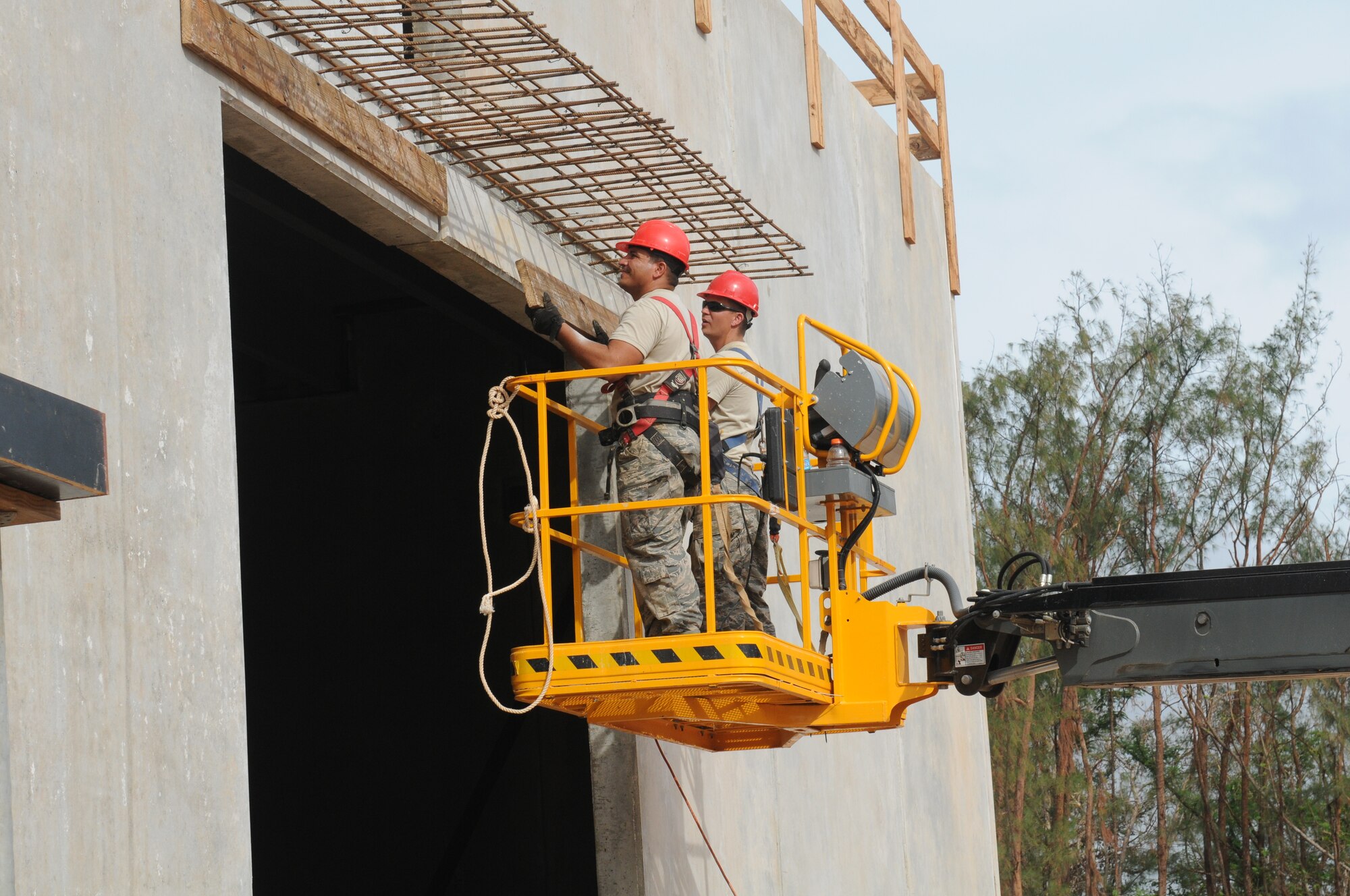 Airmen from the Virginia Air National Guard's Virginia Beach-based 203rd RED HORSE Squadron and the 202nd RHS from Camp Blanding, Florida improve and train upon essential skills June 2, 2015 during a joint-tasking training mission to erect a Facilities Systems Training facility at Anderson Air Force Base, Guam. The FST is a one-story, pre-cast concrete "Tilt-Up Construction" building using troop labor, under the Air National Guard Deployment for Training program. The facility is designed to withstand hurricane-force winds and earthquakes. (U.S. Air National Guard photo by Tech. Sgt. Meghan Skrepenski/Released)