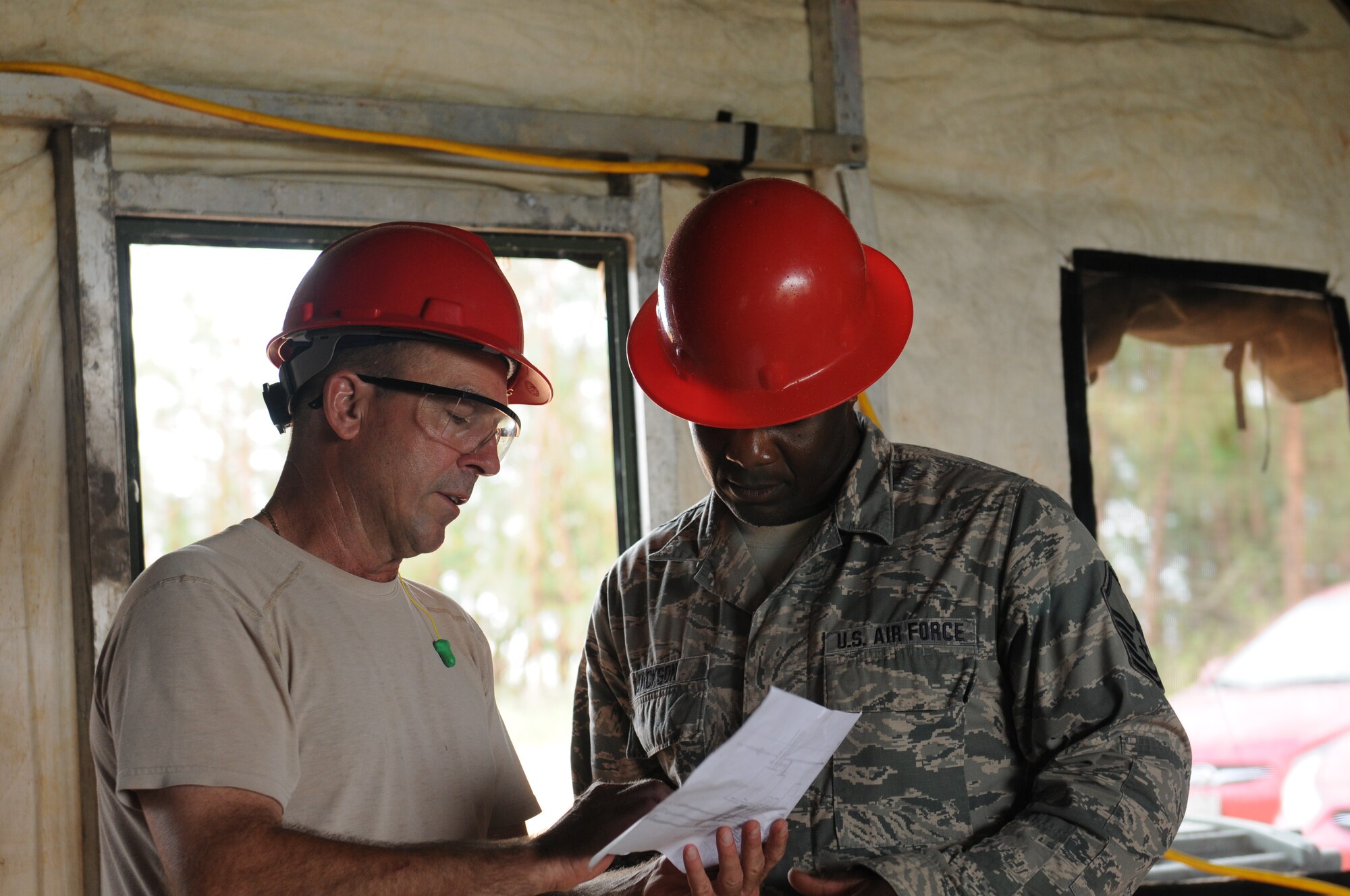 Airmen from the Virginia Air National Guard's Virginia Beach-based 203rd RED HORSE Squadron and the 202nd RHS from Camp Blanding, Florida improve and train upon essential skills June 2, 2015 during a joint-tasking training mission to erect a Facilities Systems Training facility at Anderson Air Force Base, Guam. The FST is a one-story, pre-cast concrete "Tilt-Up Construction" building using troop labor, under the Air National Guard Deployment for Training program. The facility is designed to withstand hurricane-force winds and earthquakes. (U.S. Air National Guard photo by Tech. Sgt. Meghan Skrepenski/Released)