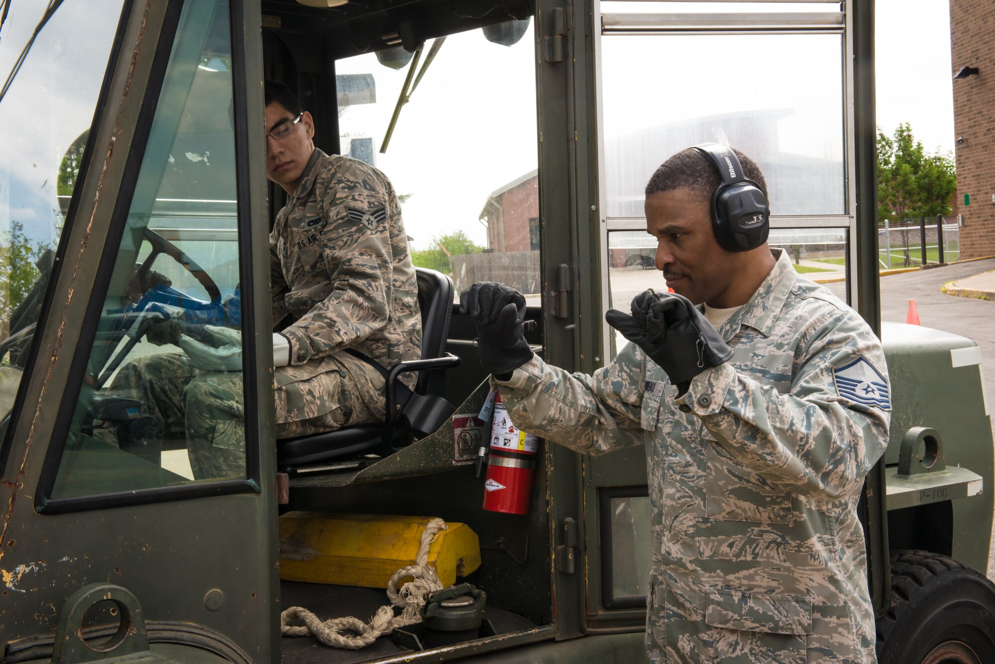 Master Sgt. John Ambeau, 27th Aerial Port Squadron, guides Senior Airman Joshua Huber through a road course while instructing him on forklift operations during the unit training assembly weekend. (U.S Air Force photo by Staff Sgt. Corban Lundborg/Released)