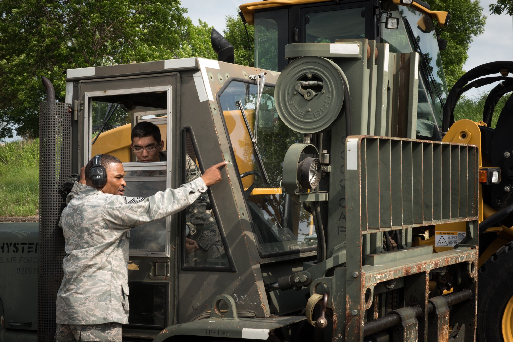 Master Sgt. John Ambeau, 27th Aerial Port Squadron, guides Senior Airman Joshua Huber through a road course while instructing him on forklift operations during the unit training assembly weekend. (U.S Air Force photo by Staff Sgt. Corban Lundborg/Released)
