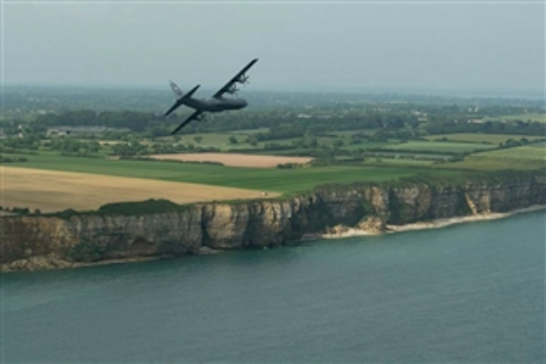 Flying over battlefield cliffs near Pointe du Hoc, in the Normandy, France, region, June 5, 2015, a U.S. Air Force C-130J Hercules aircraft practices maneuvers for 71st D-Day commemorative events. More than 380 American service members are participating in ceremonies for the remembrance of the allied invasion, June 6, 1944.