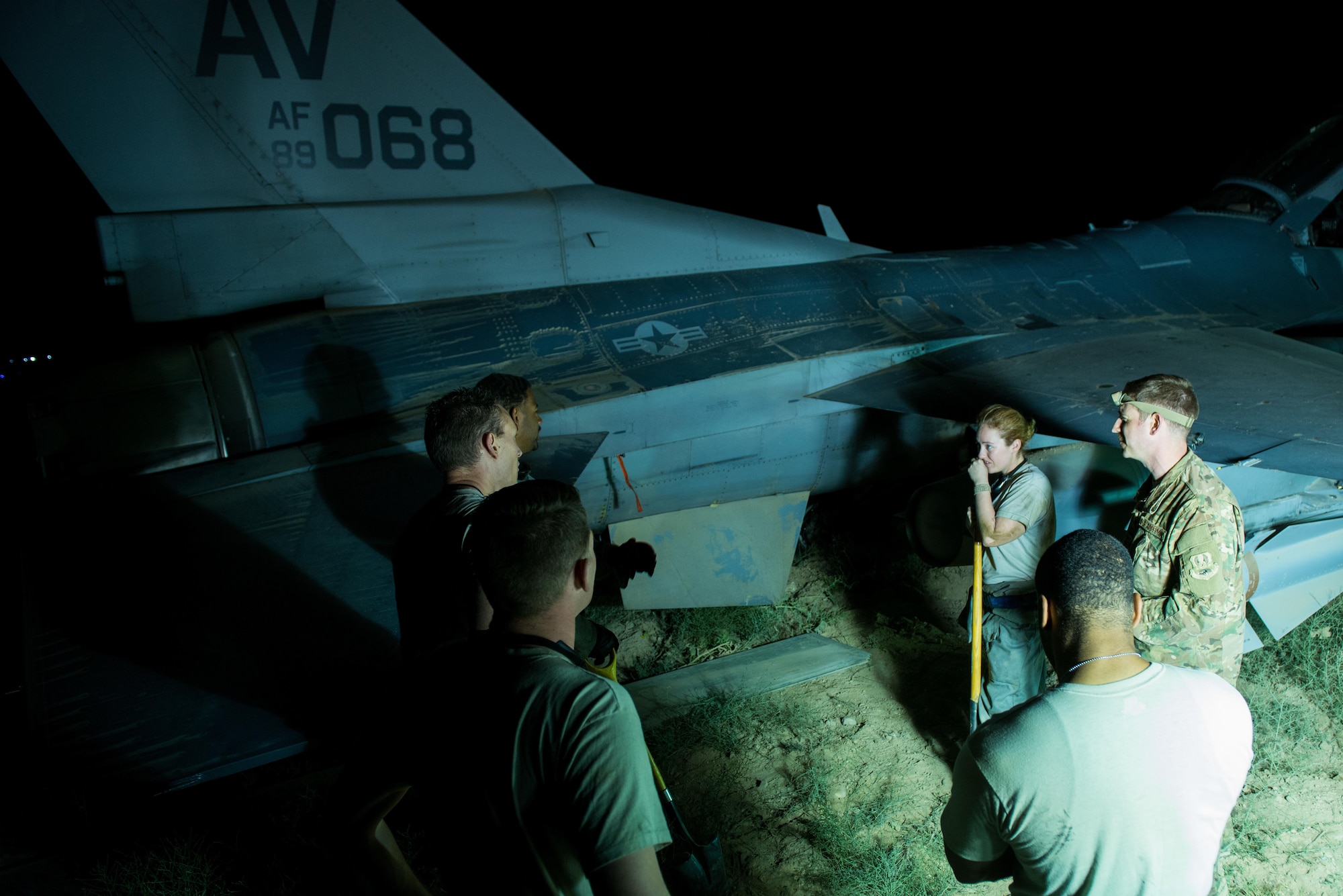 U.S. Airmen assigned to the 455th Expeditionary Aircraft Maintenance Squadron take a break from working to replace a tire on an F-16 Fighting Falcon aircraft that departed the runway while landing at Bagram Air Field, Afghanistan, May 4, 2015. The 455th EAMXS maintainers were able to expeditiously recover the aircraft and return the runway to operational status; the pilot was uninjured while the F-16 only sustained minor damage in the mishap. (U.S. Air Force photo by Tech Sgt. Joseph Swafford/Released)