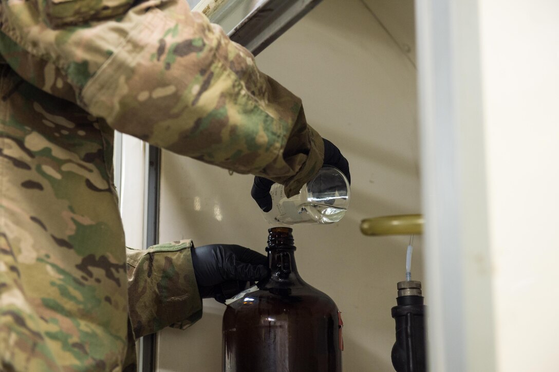 U.S. Air Force Staff Sgt. Joseph Guzman, 455th Expeditionary Logistics Readiness Squadron Fuels Laboratory noncommissioned officer in charge, conducts a fuel sample analysis at Bagram Air Field, Afghanistan, May 16, 2015. Guzman ensures the fuel delivered to aircraft at Bagram meets the Air Force standard. (U.S. Air Force photo by Tech Sgt. Joseph Swafford/Released)
