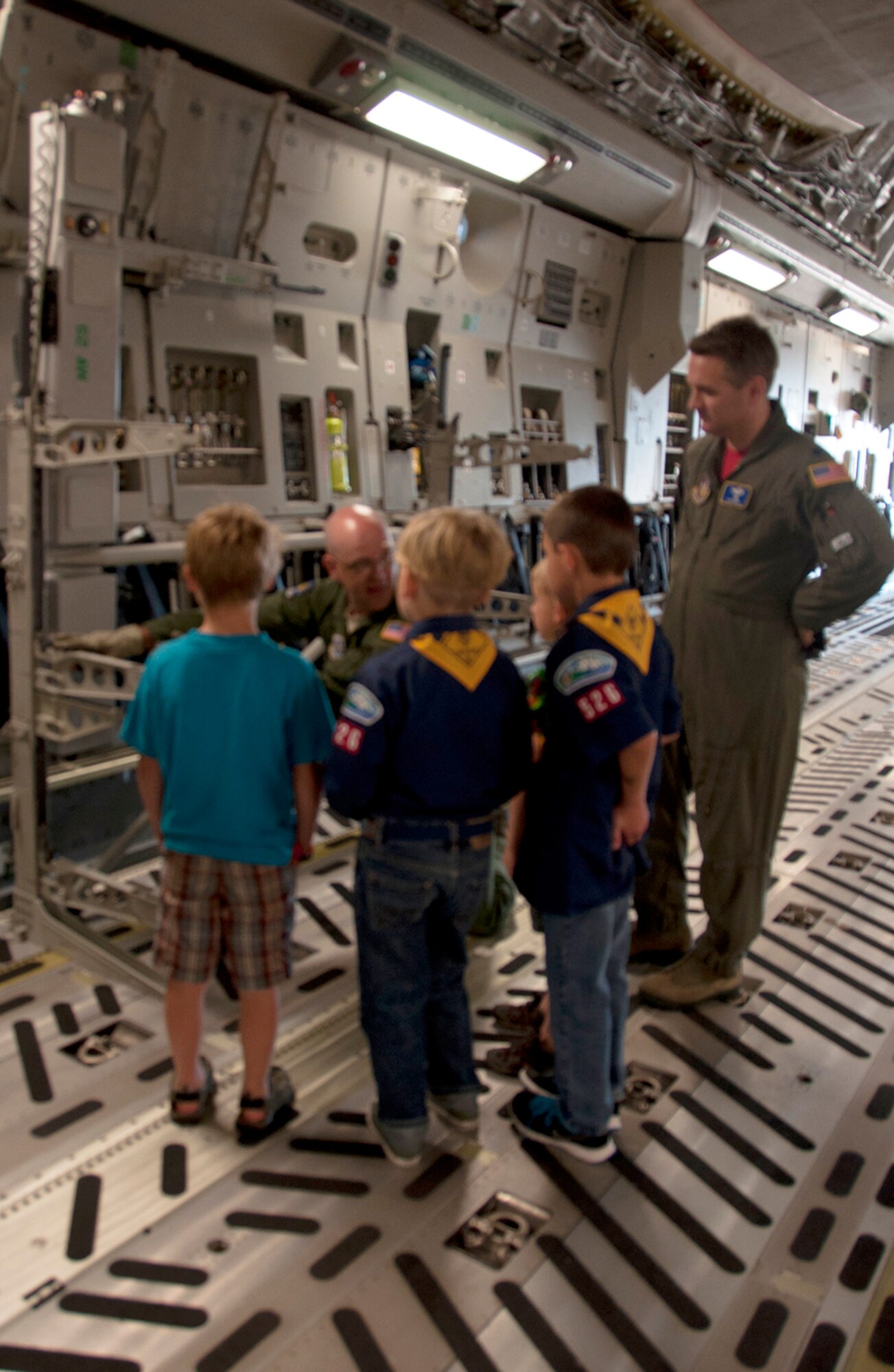 Lt. Col. Frank Nisco (right), 97th Airlift Squadron pilot, and a group of Cub Scouts listen as Tech. Sgt. Adam Roberts, 8th Airlift Squadron loadmaster, explains how a litter stanchion is used onboard a C-17 Globemaster III on June 6. Children from Cub Scouts Pack 526 also visited the control tower and learned about aircrew flight equipment during a base tour. (Air Force Reserve photo by Master Sgt. Minnette Mason)