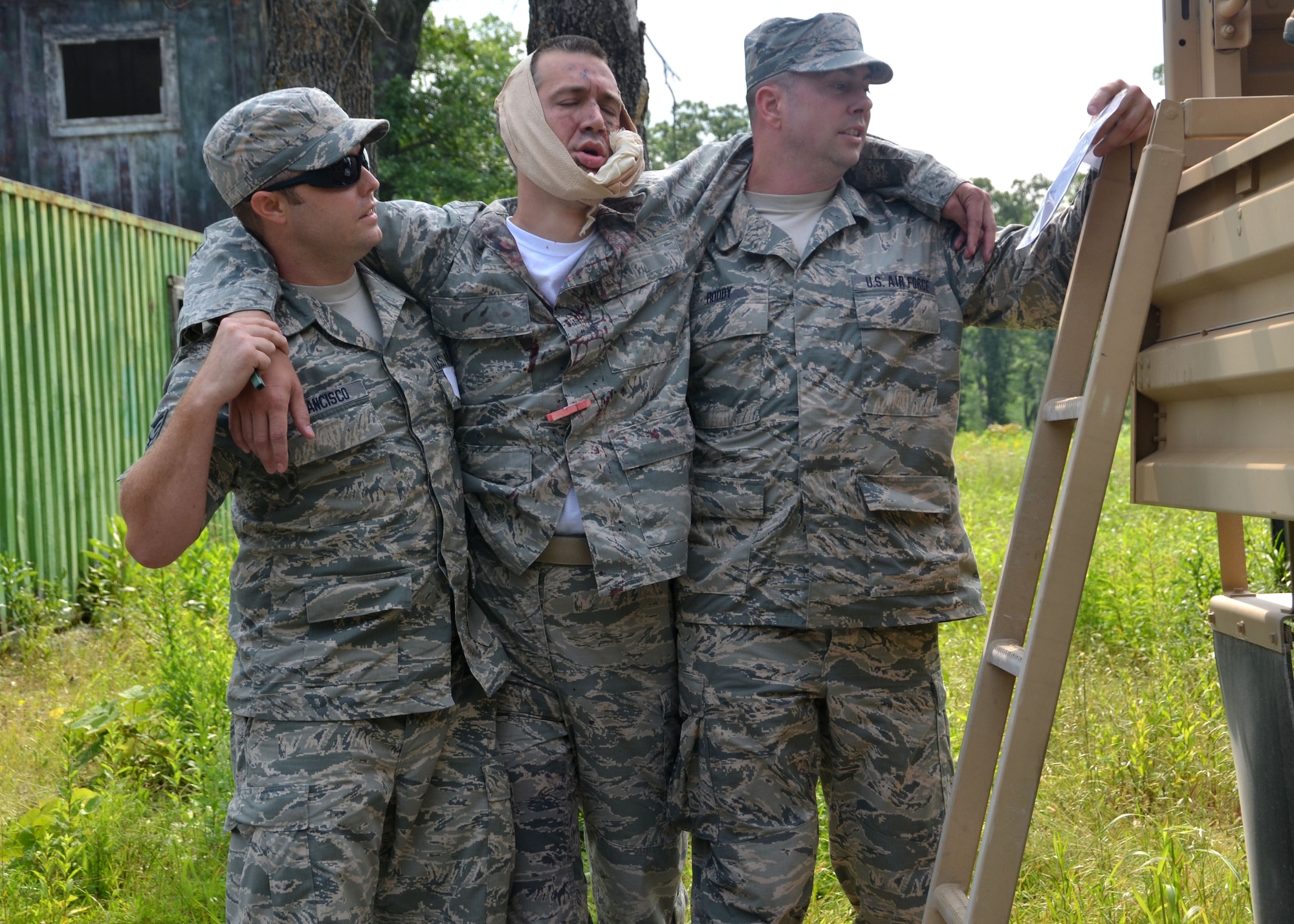 Senior Airman Joel Francisco, a munitions technician with the 131st
Maintenance Squadron, and Tech. Sgt. Jason Roddy of the 239th Combat
Communications Squadron, help to evacuation of their wingman Senior
Airman Scott McElfresh, 131st MXS.  The Airmen participated in a simulated tornado exercise during annual training to help prepare them for state emergency duty. 
(U.S. Air National Guard photo by Tech. Sgt. Traci Payne)