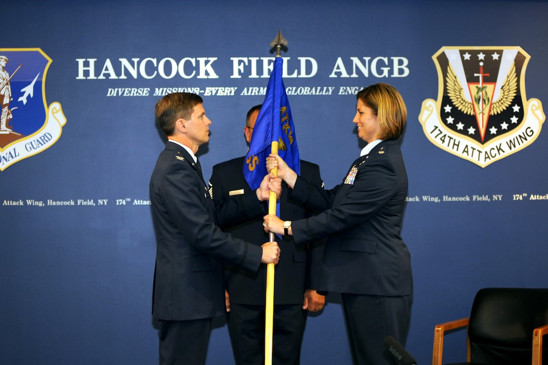 New York Air National Guard Lt. Col. Michele L. Kilgore receives the Operation Group flag from Col. Greg Semmel, 174th Attack wing commander, at Hancock Field in Syracuse, N.Y. 7 June 2015.  Kilgore was presented with the ceremonial flag at the Assumption of Command ceremony where she officially took over as the Commander of the 174th Operations Group.  (New York Air National Guard Photo by Tech. Sgt. Jeremy M. Call/Released)